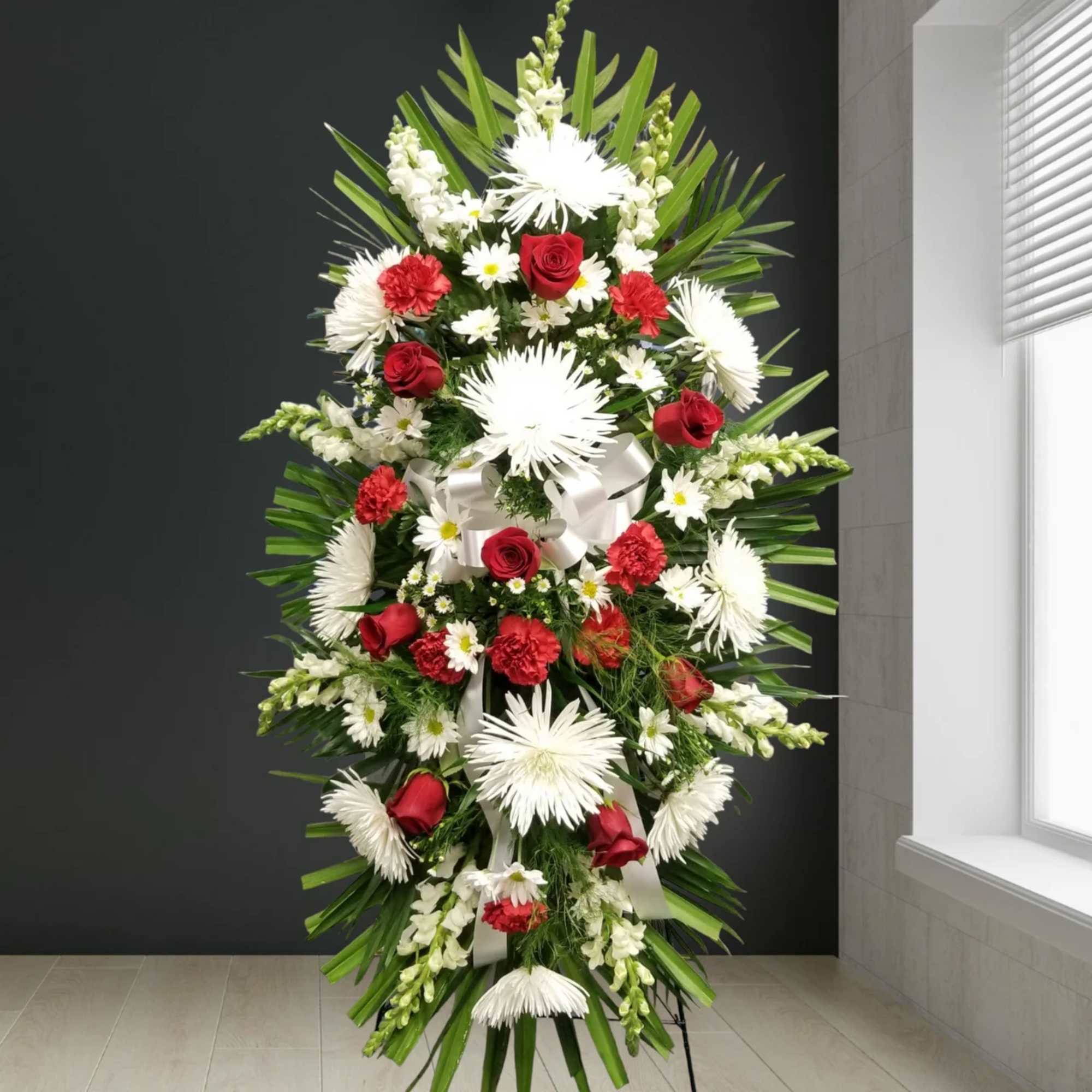 Tall standing floral spray with red roses and white daisies