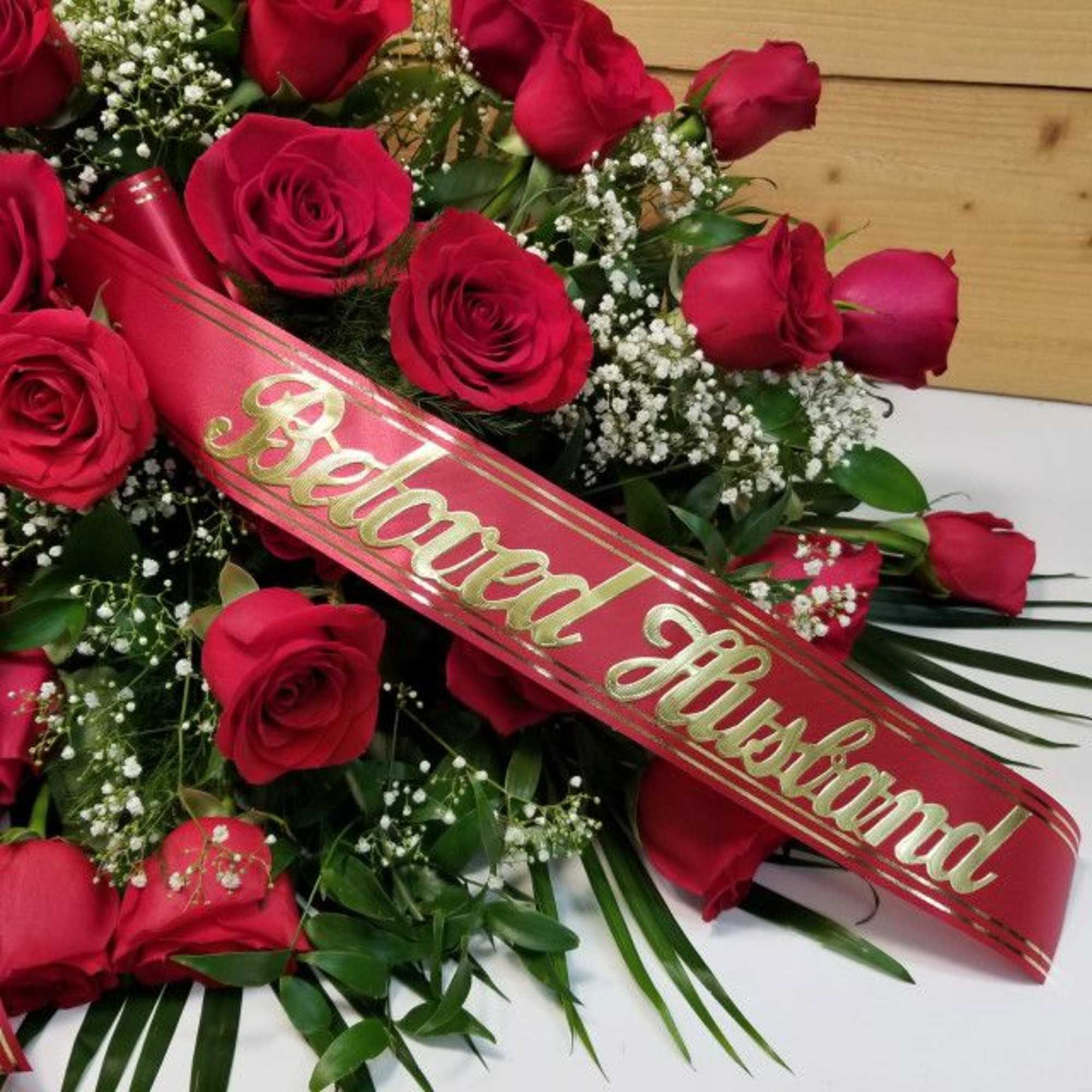 Red rose arrangement with a red "Beloved Husband" sash
