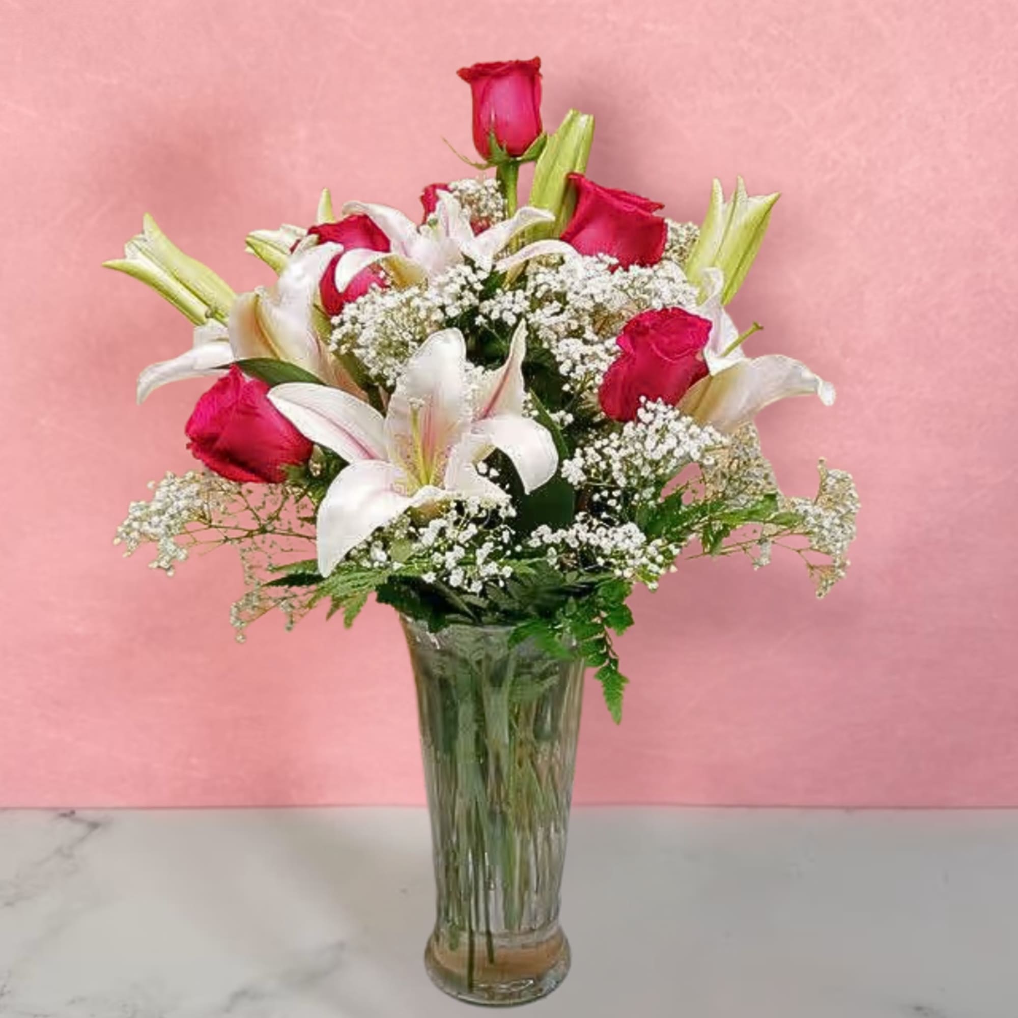 Bouquet of red roses and white lilies in a clear glass vase