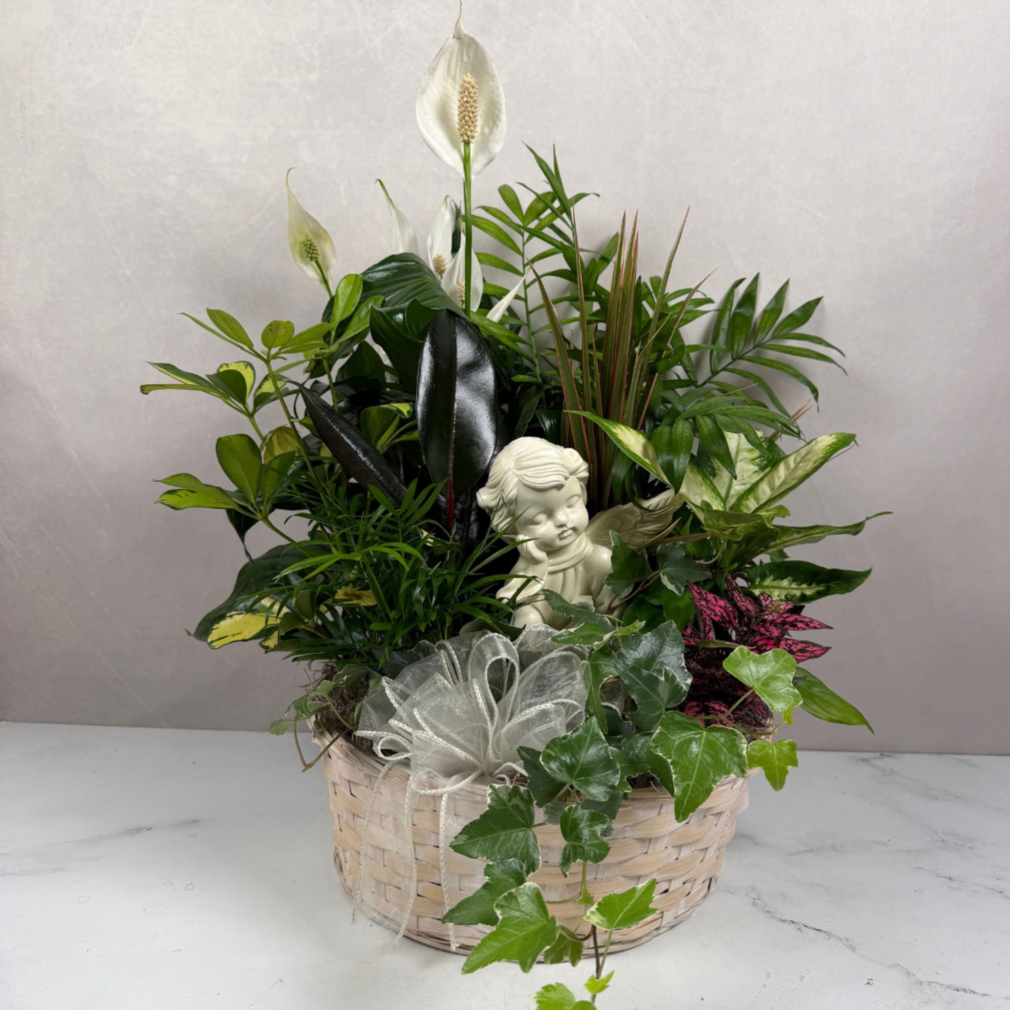 Mixed potted plants in a woven basket with a small angel figurine, photo 2 of 4