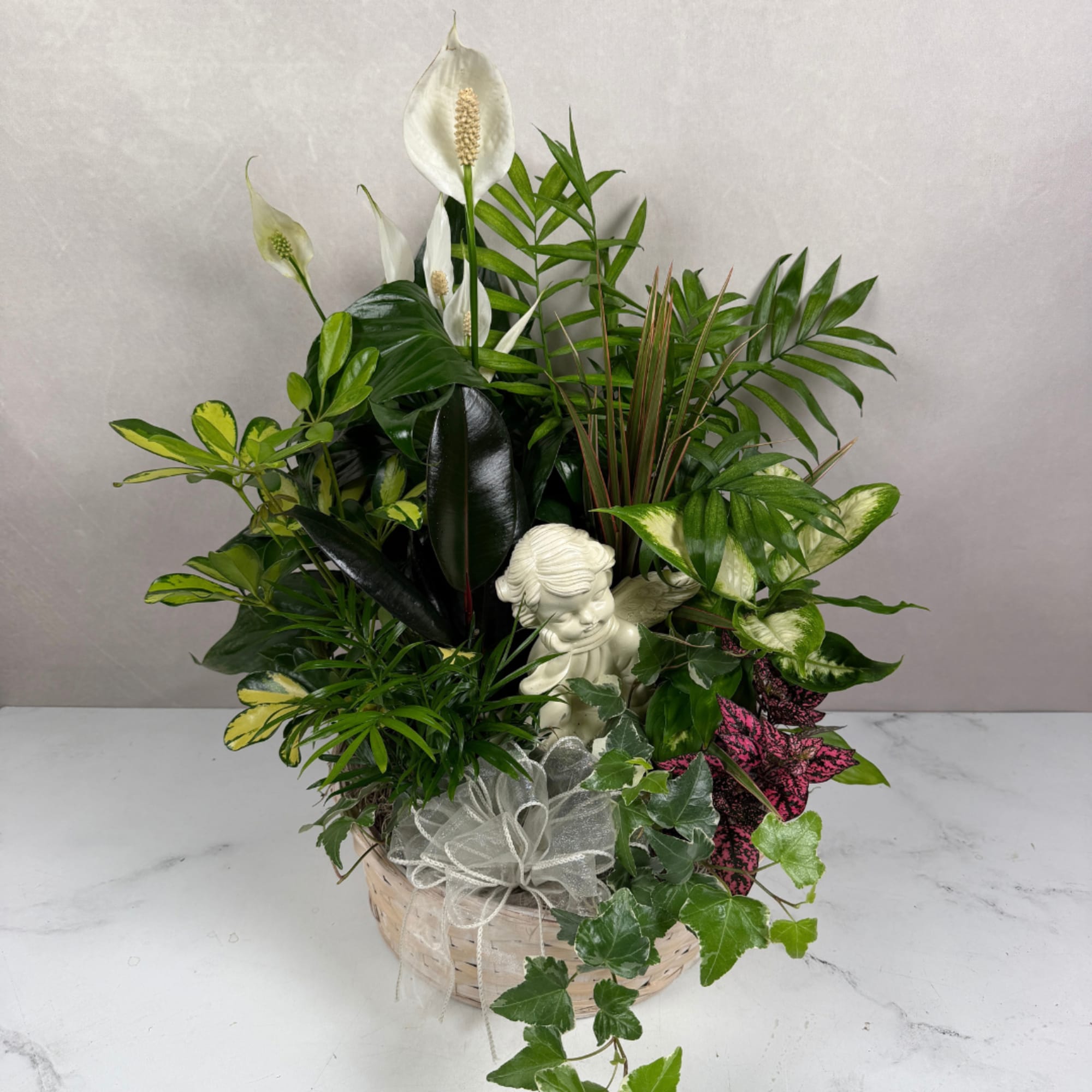 Basket planter with white peace lilies and assorted green foliage