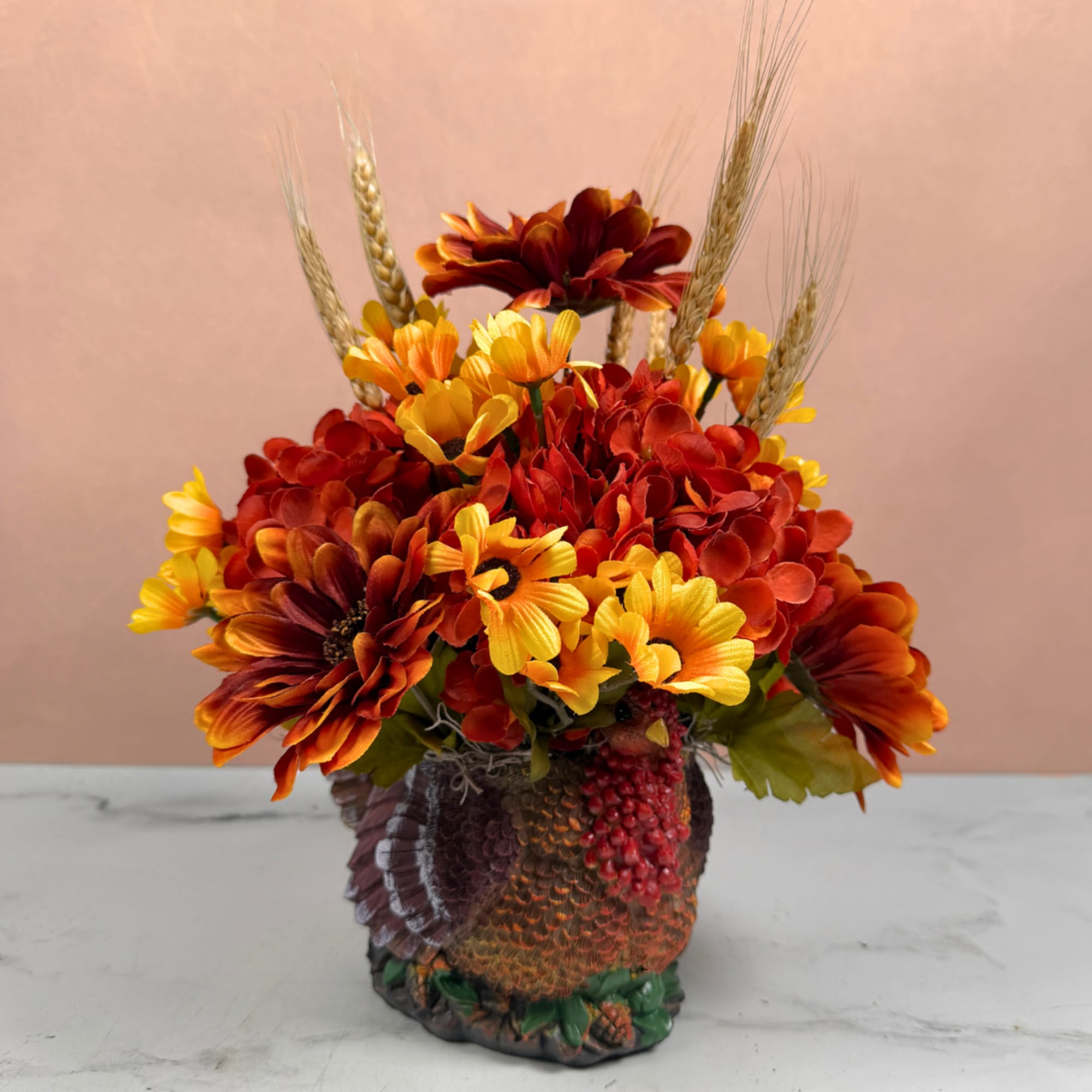 Autumn floral arrangement with red and yellow flowers in a textured vase