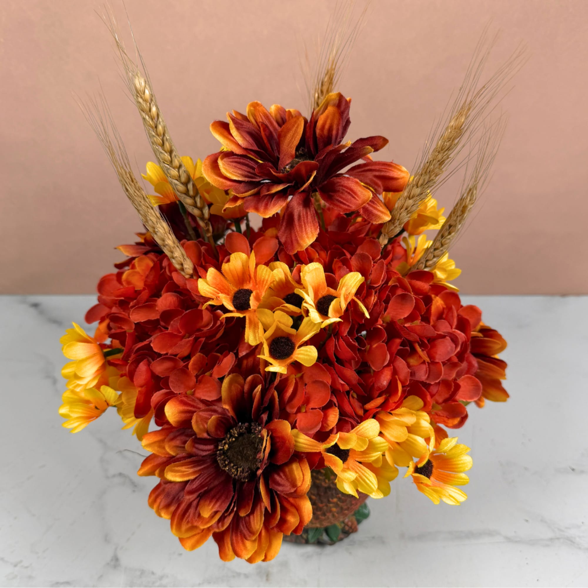 Bouquet of orange and yellow flowers with wheat stems in a vase