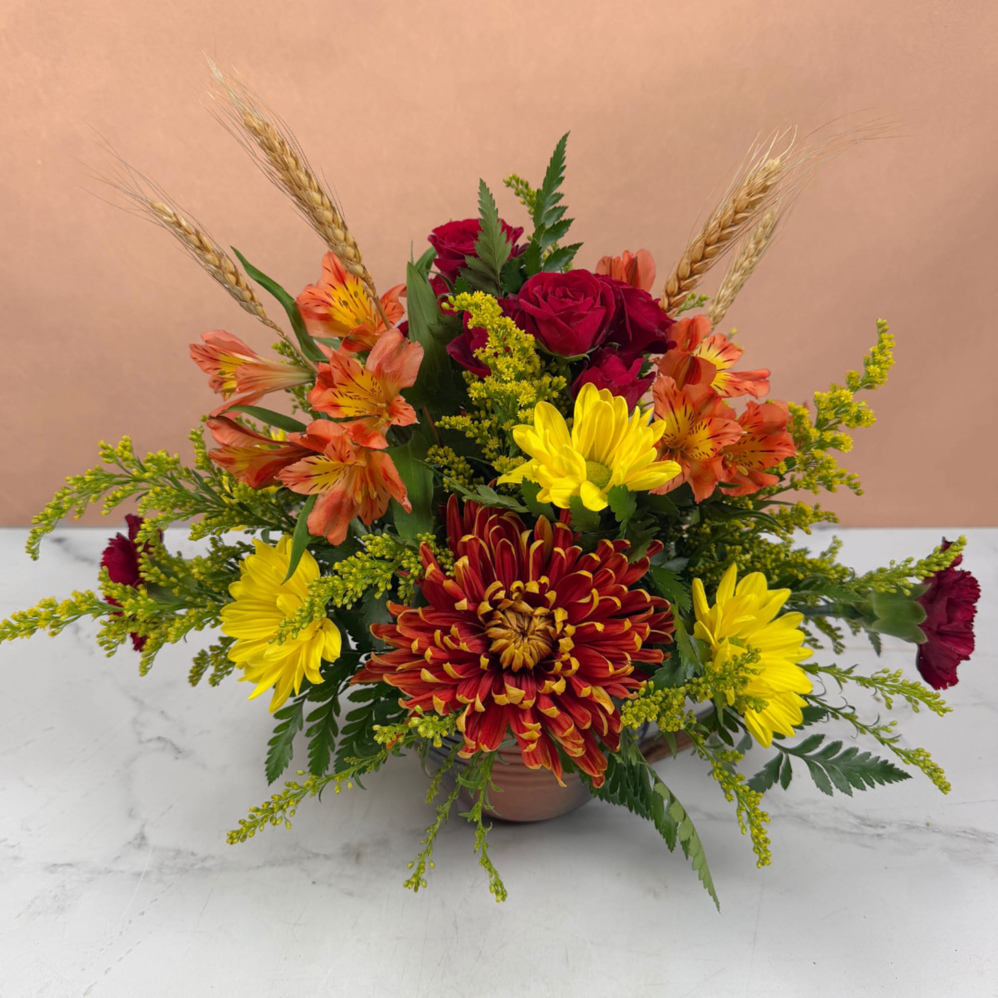 Mixed bouquet with red roses, yellow chrysanthemums, and orange alstroemeria in a vase
