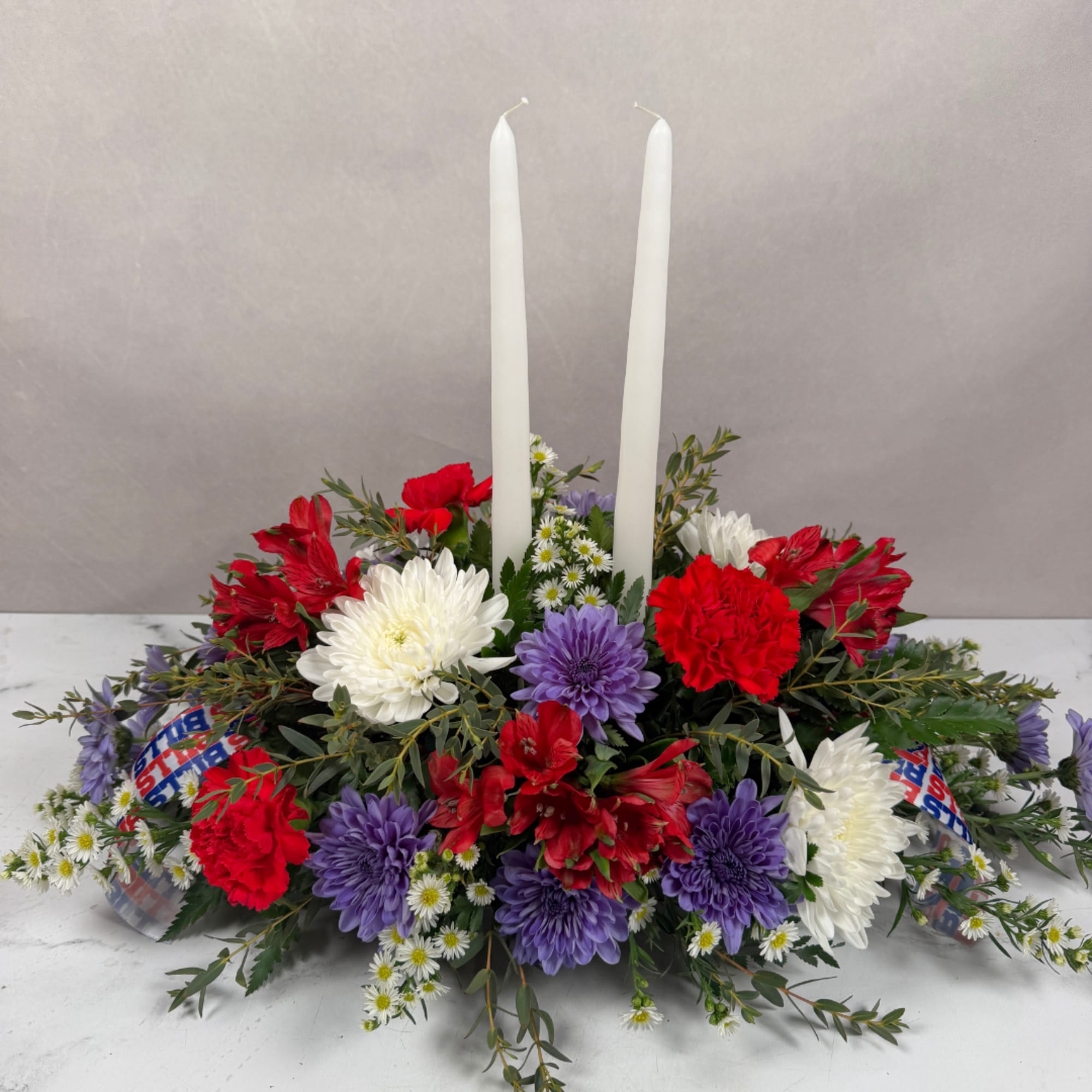 Red, white, and purple floral centerpiece with two white taper candles, photo 3 of 4