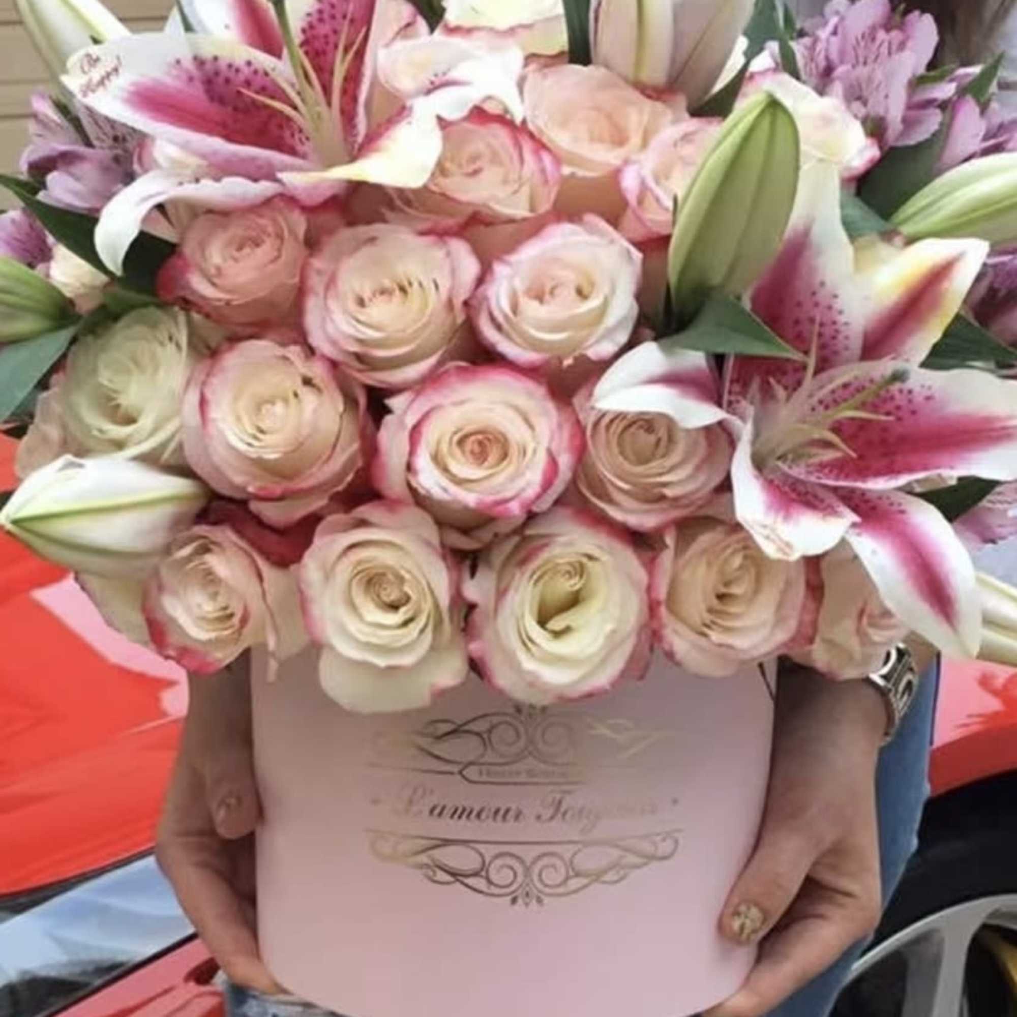 Pink and white bouquet of roses and lilies in a pale pink box