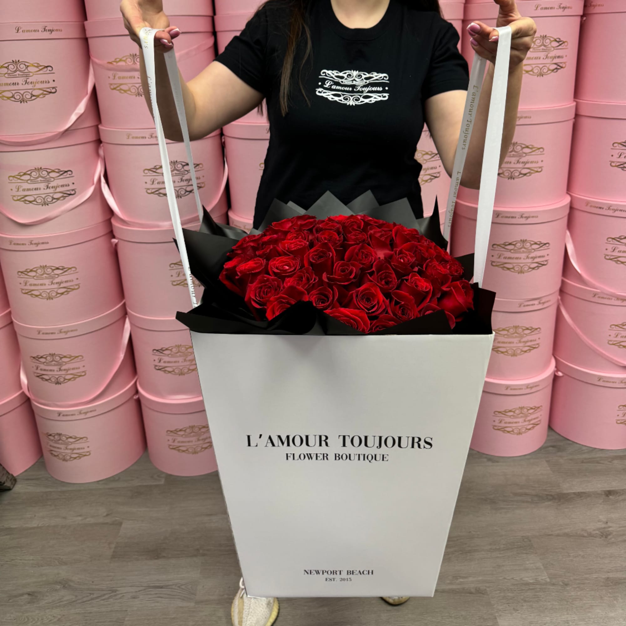 Large bouquet of red roses in a white box with black wrapping