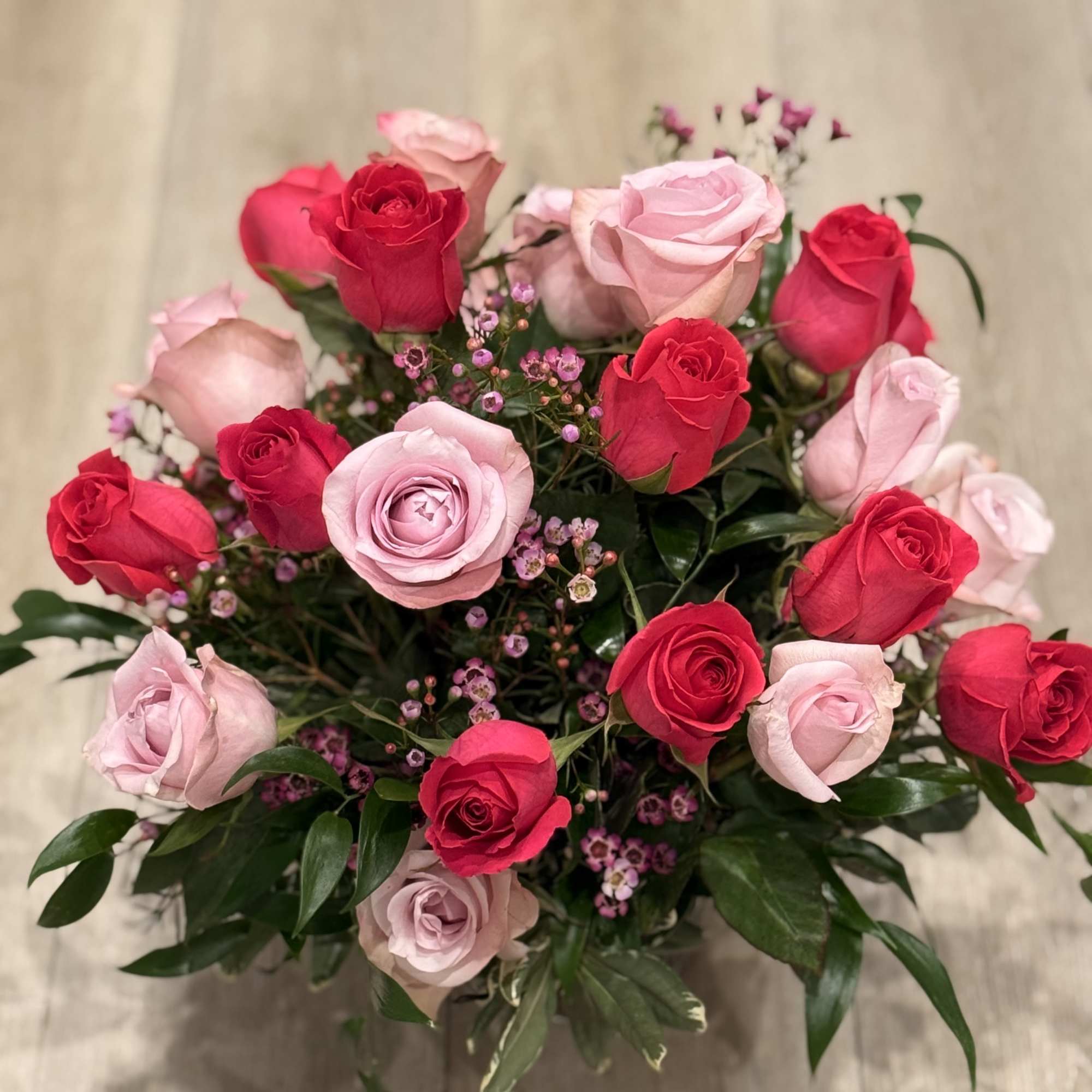 Short roses arrangement with light and hot pink roses, wax flower and