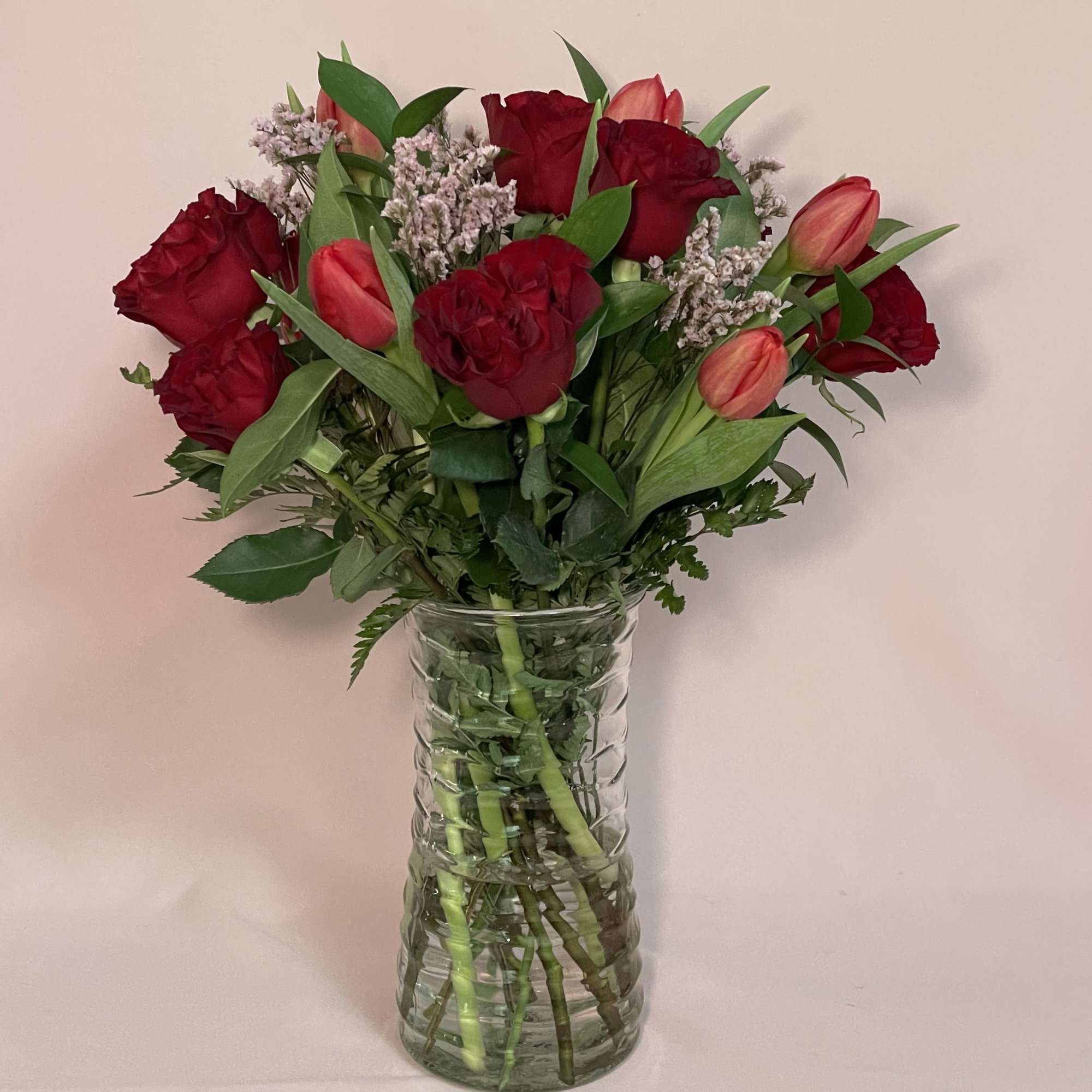 Garden Roses, tulips, seasonal greens and limonium.
