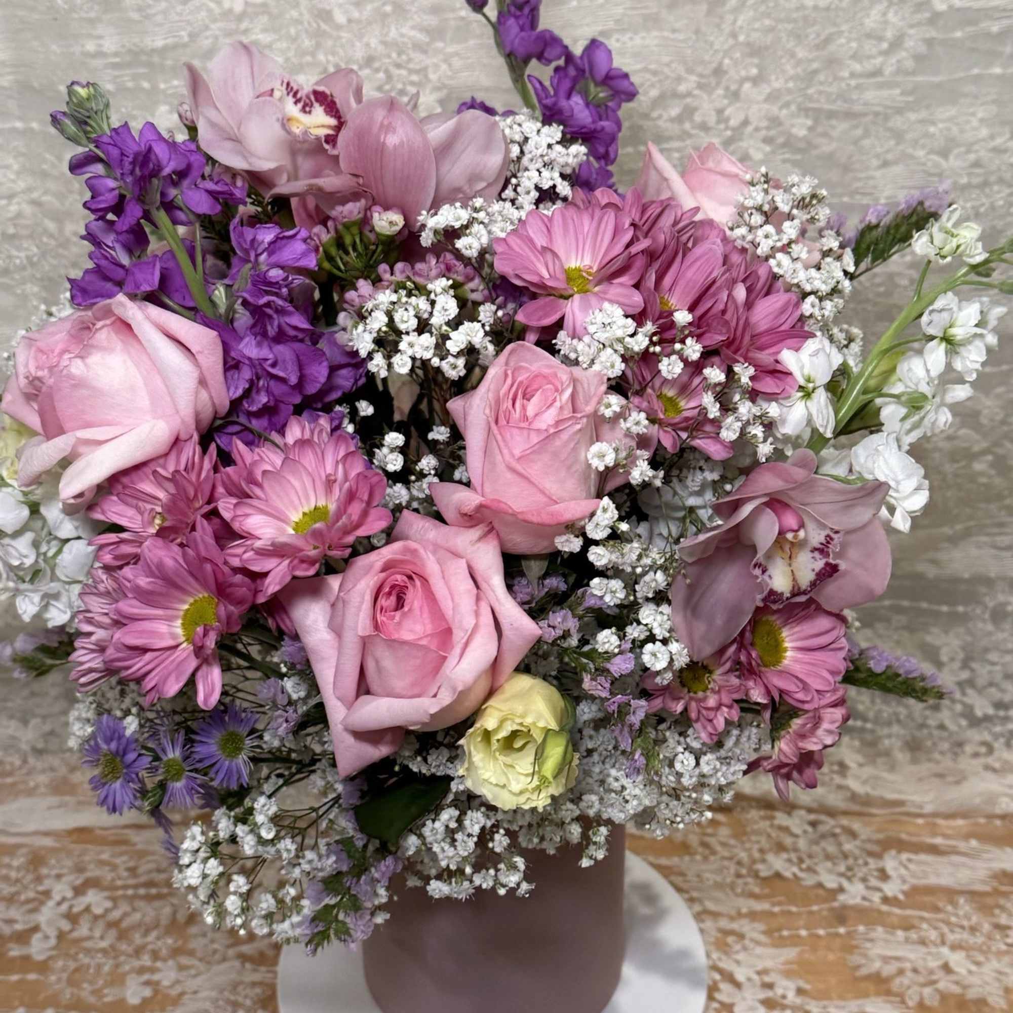 Lisianthus, Orchids, Roses, Stock flowers, spray Mums and Asters in a light
