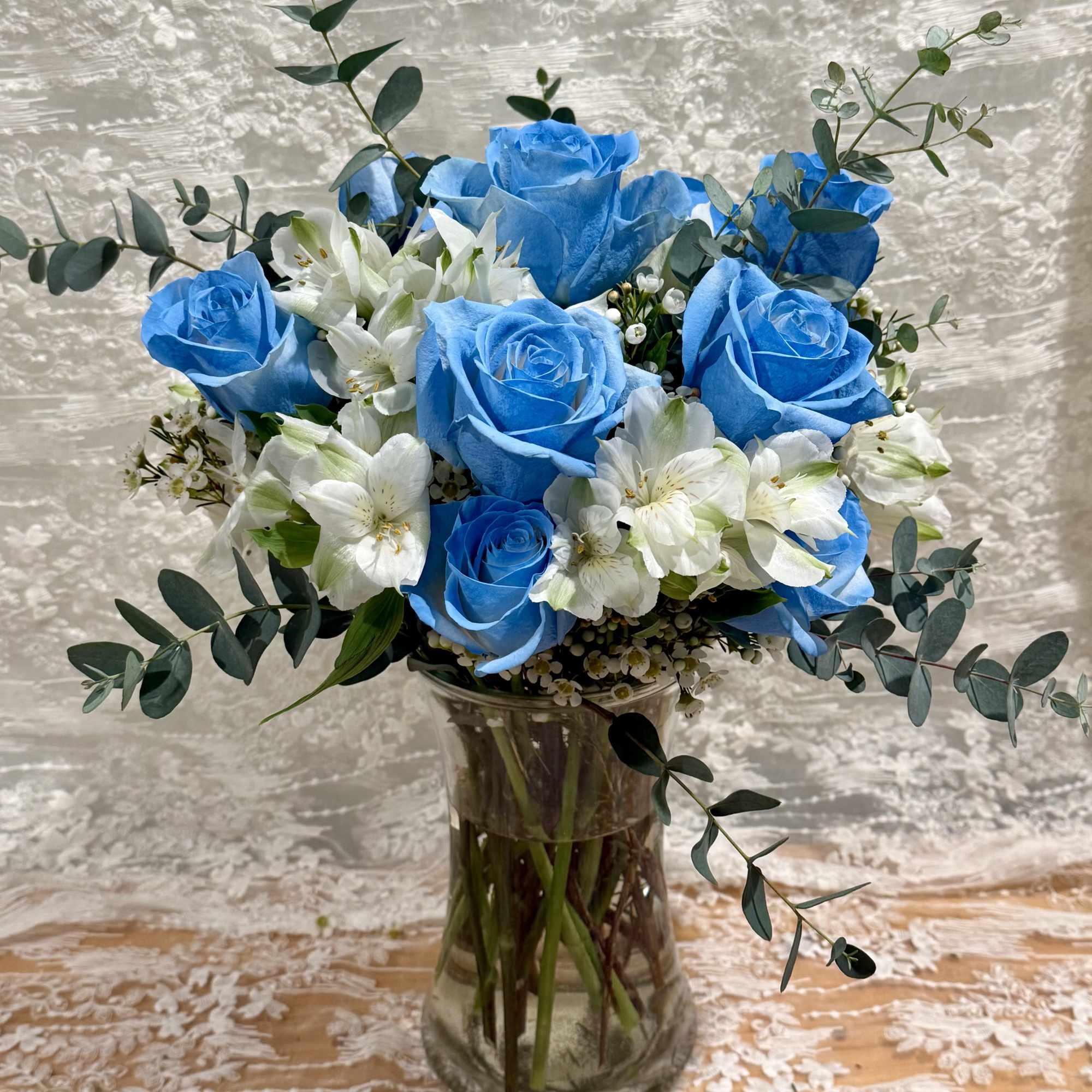 Dozen baby blue roses with Alstroemeria and wax flower 