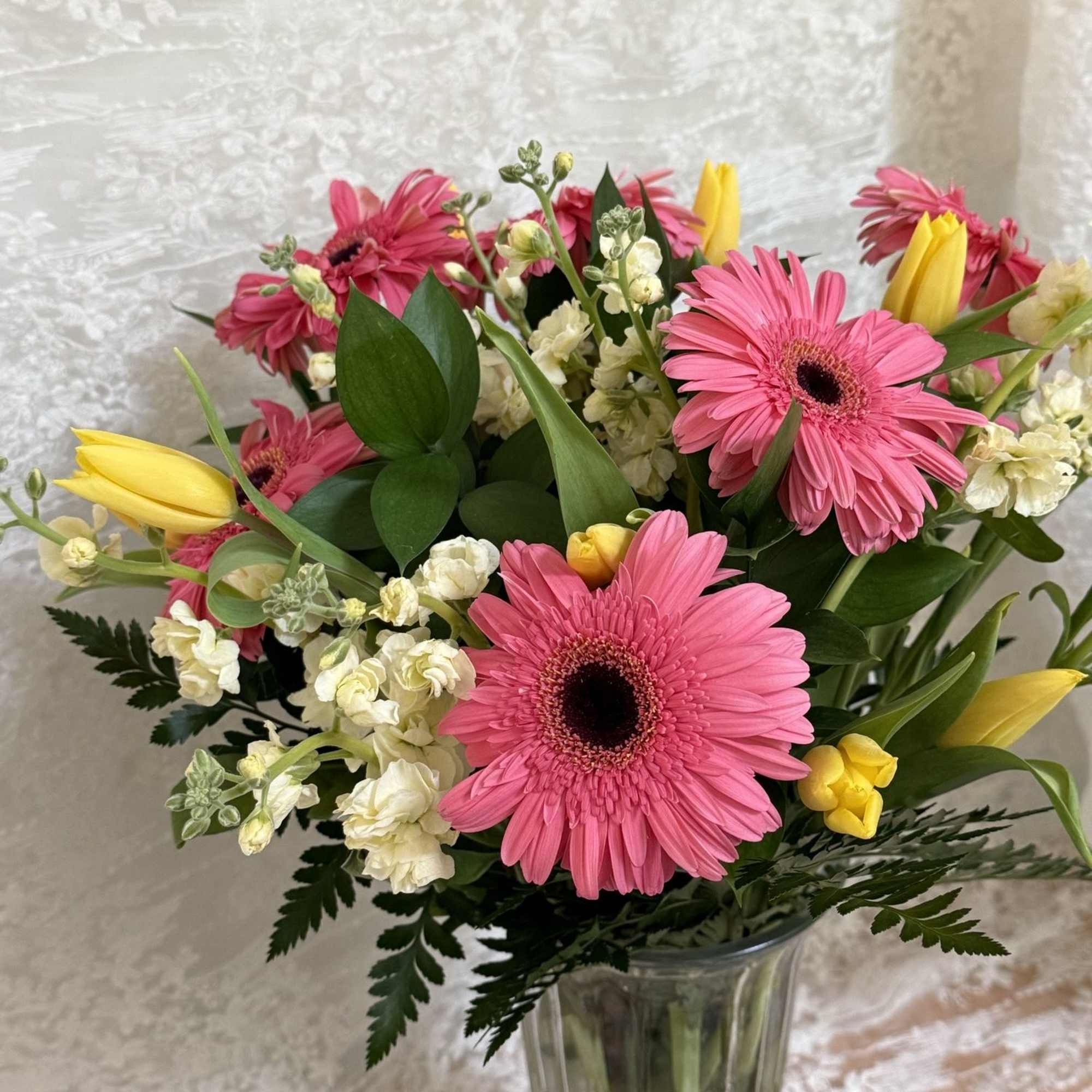 A mixture of daisies and tulips with stock line flowers.