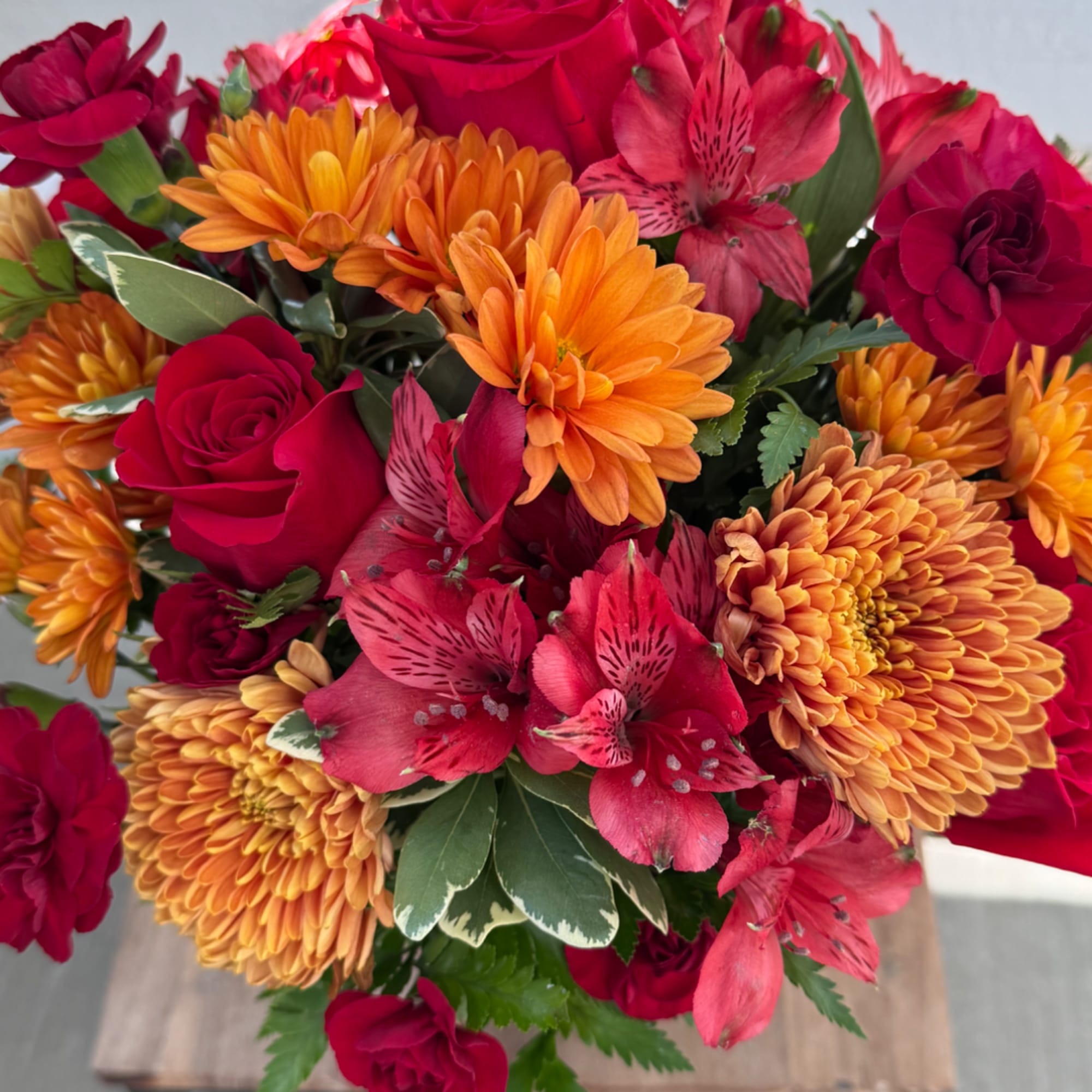 Bouquet of red roses, orange chrysanthemums, and pink alstroemeria