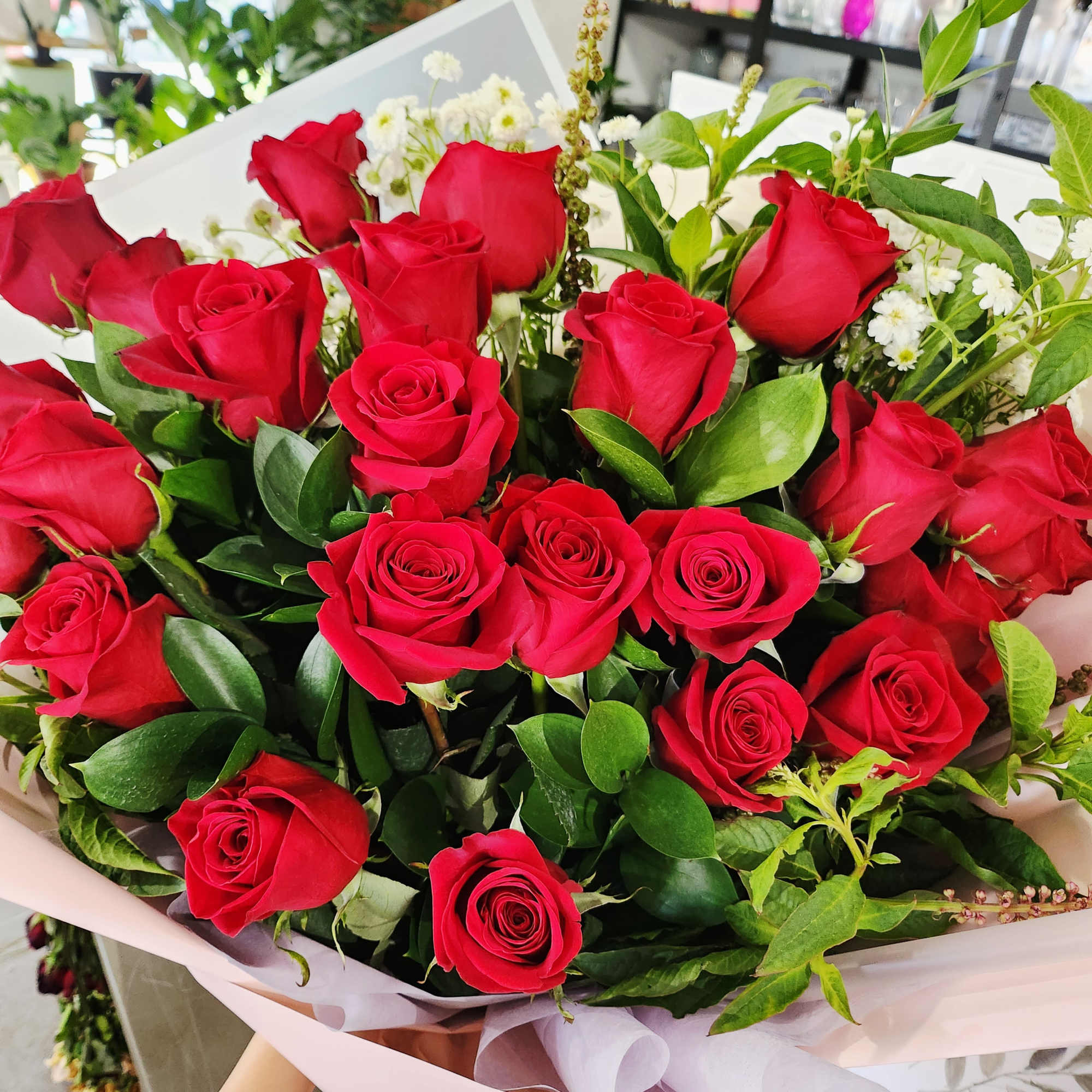 Bouquet of red roses with white filler flowers and greenery