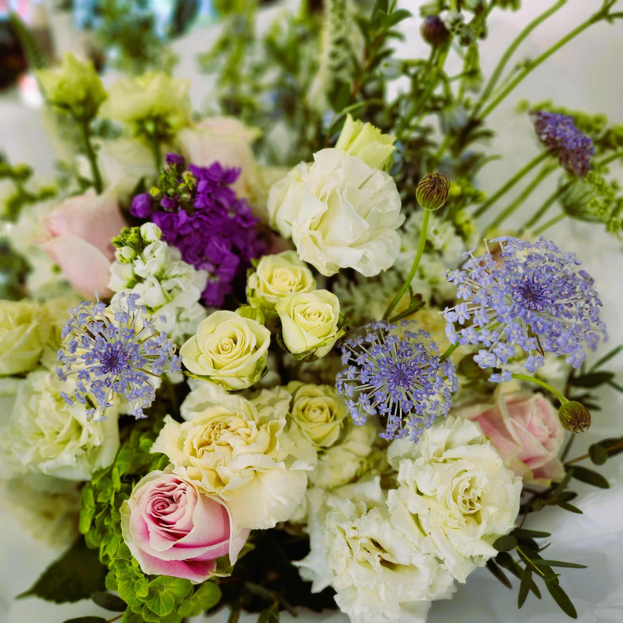 Bouquet of cream, pink, and purple flowers with mixed blooms