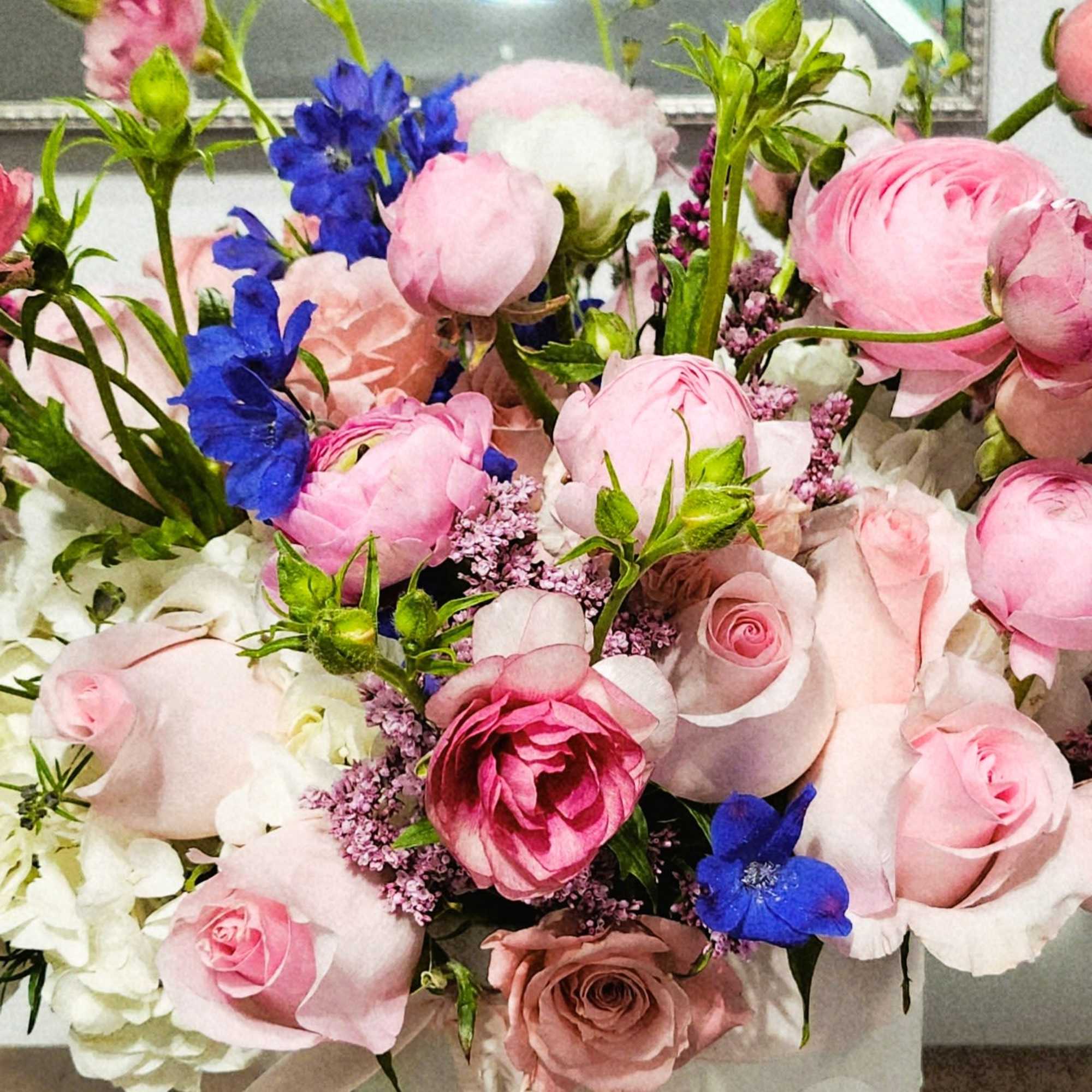 Bouquet of pink and white flowers with bright blue accents