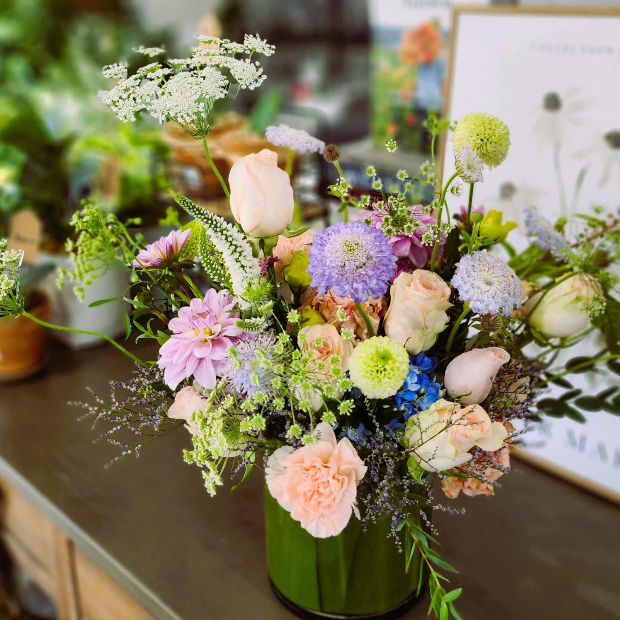 Pastel mixed flower arrangement in a green vase