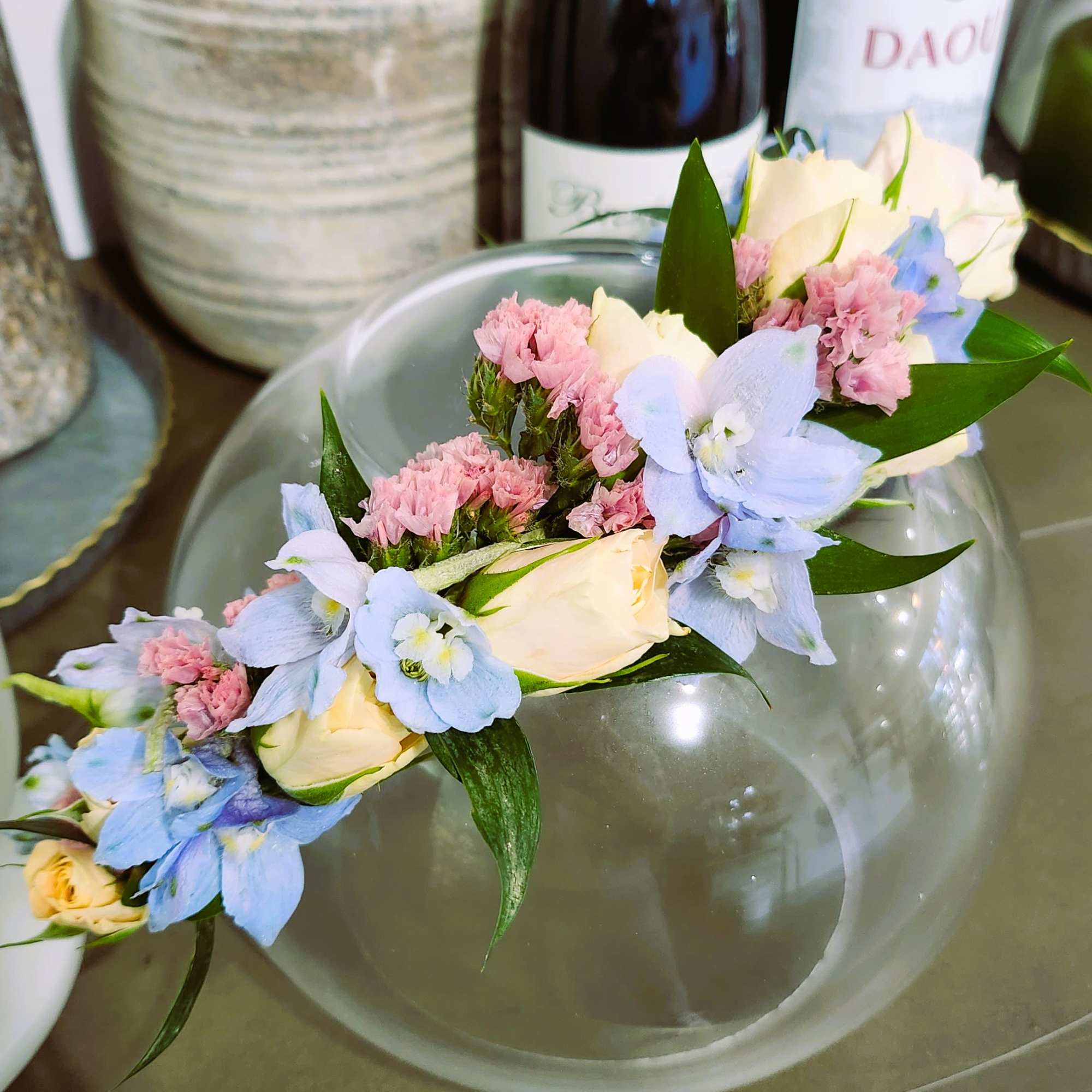 Floral crown with pale roses, blue flowers, and pink filler blooms