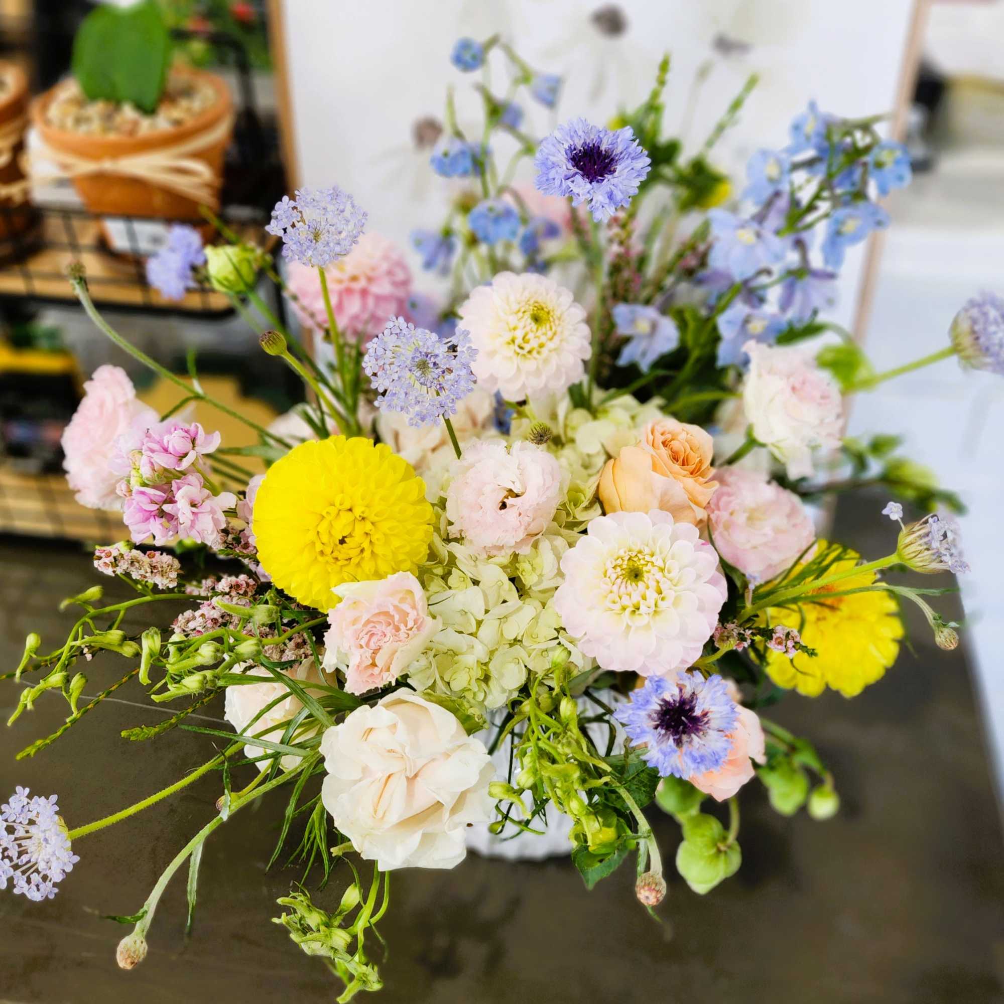 Mixed pastel bouquet with yellow and white blooms in a vase