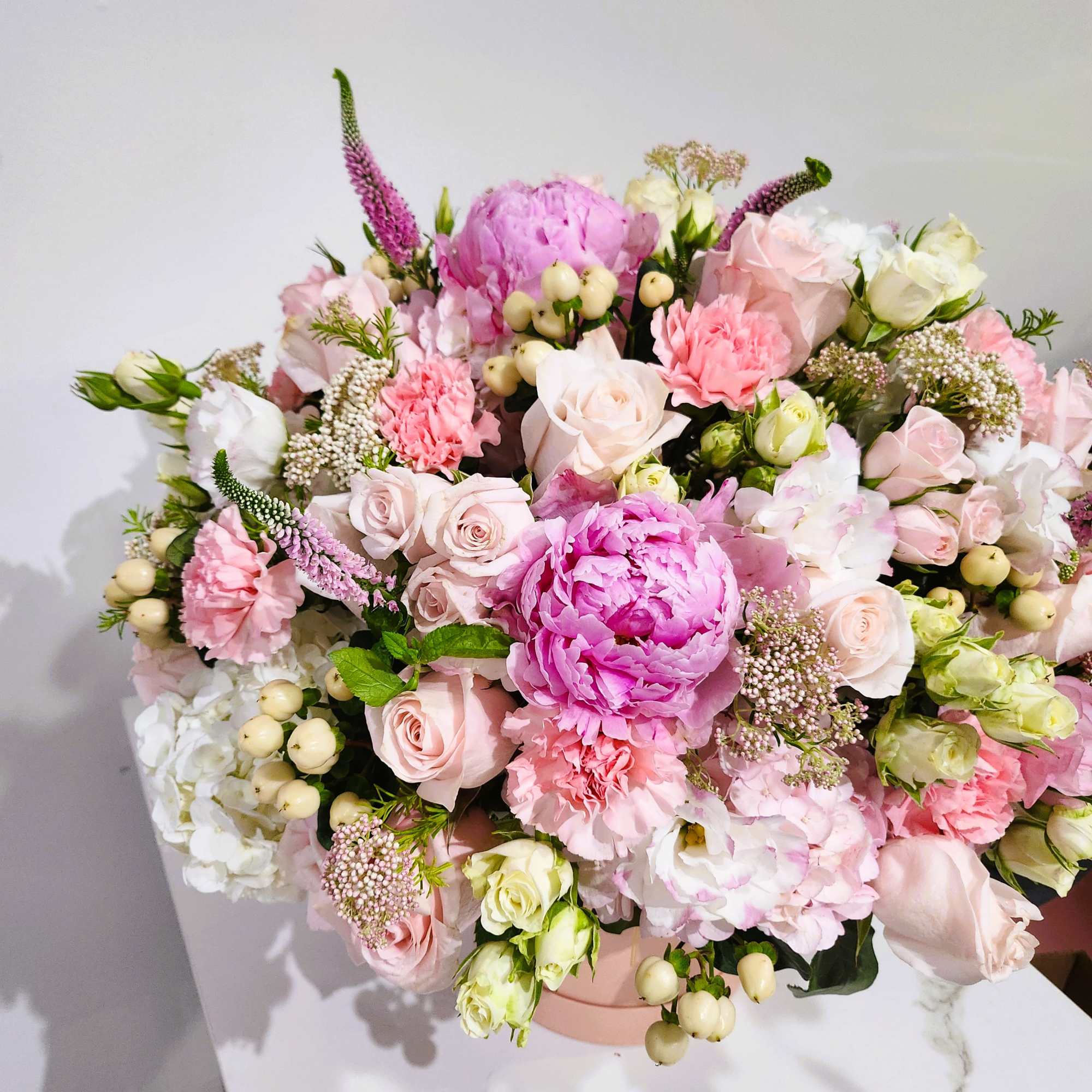Large pastel bouquet in a pink box with roses, peonies, and carnations