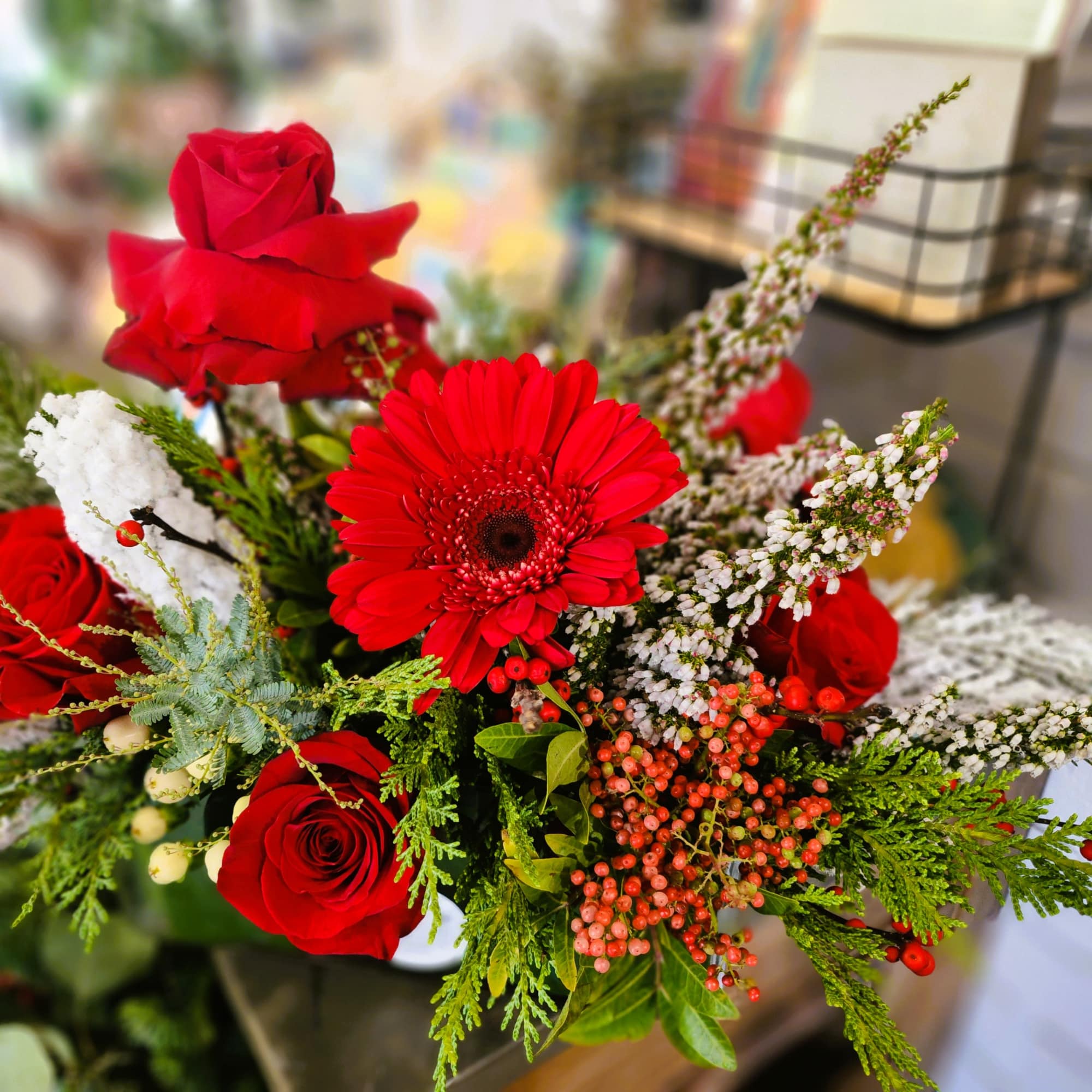 Red roses and a red gerbera daisy in a mixed bouquet