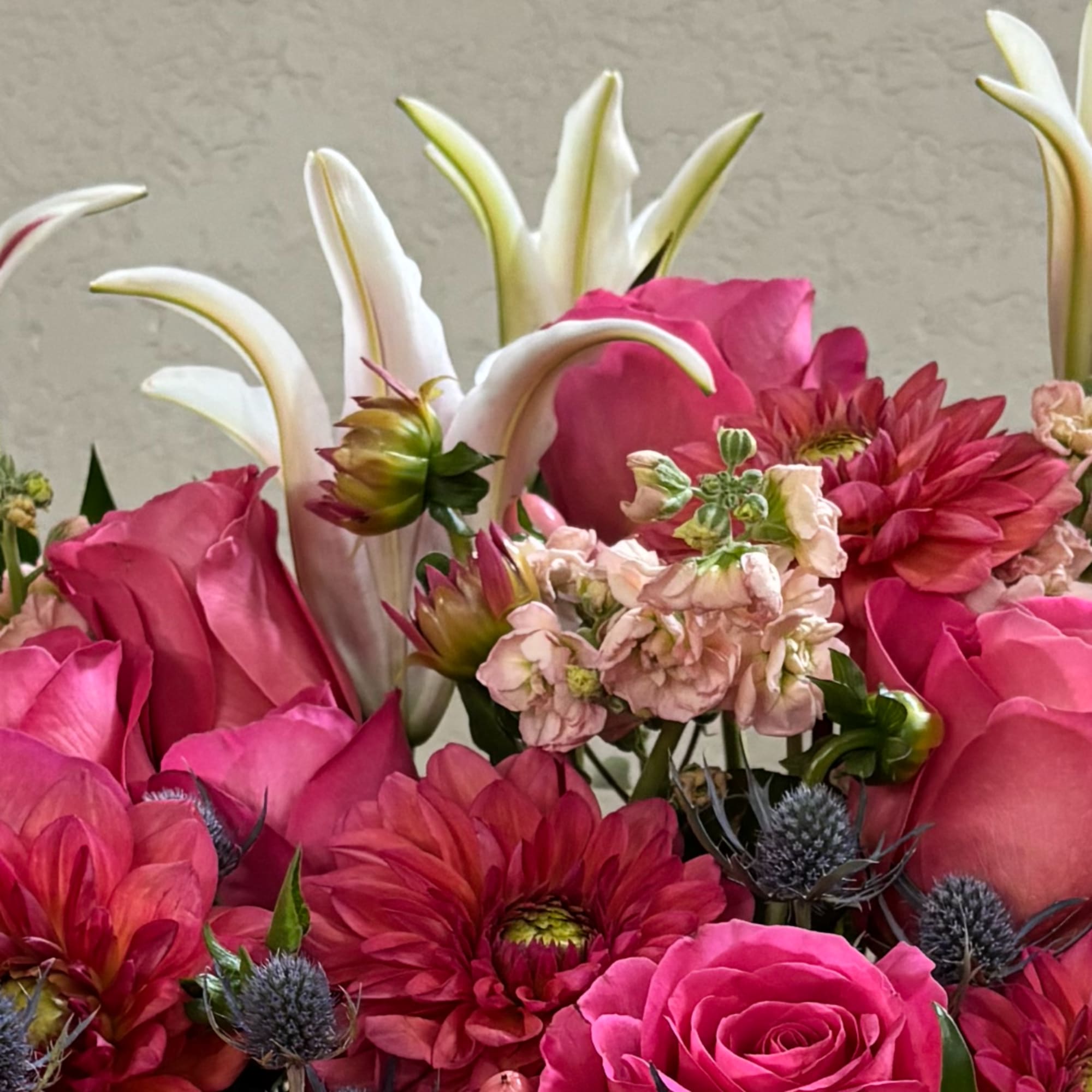 Pink roses and red dahlias with white calla lilies in a mixed bouquet