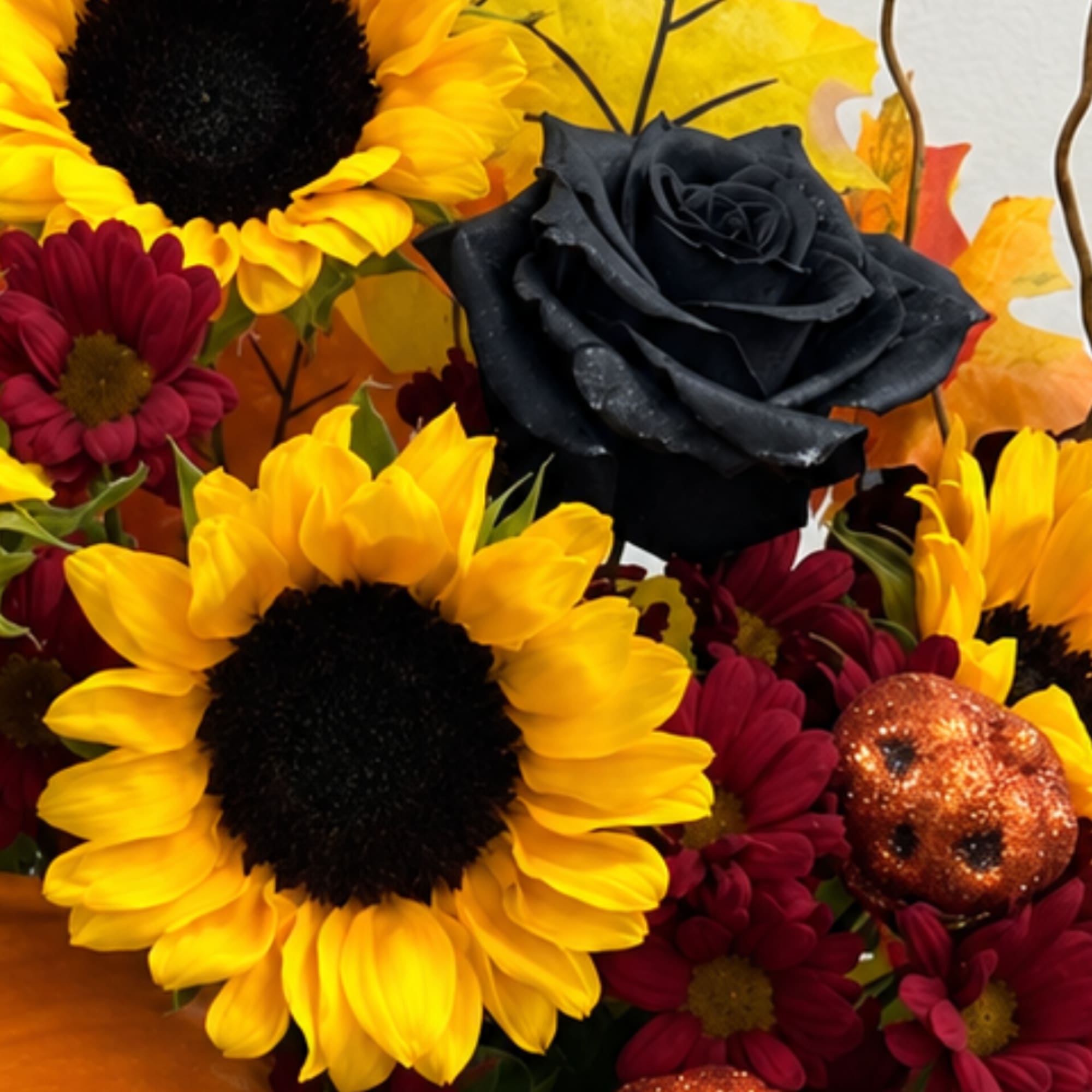 Sunflowers and dark roses with burgundy daisies and a glittery pumpkin accent