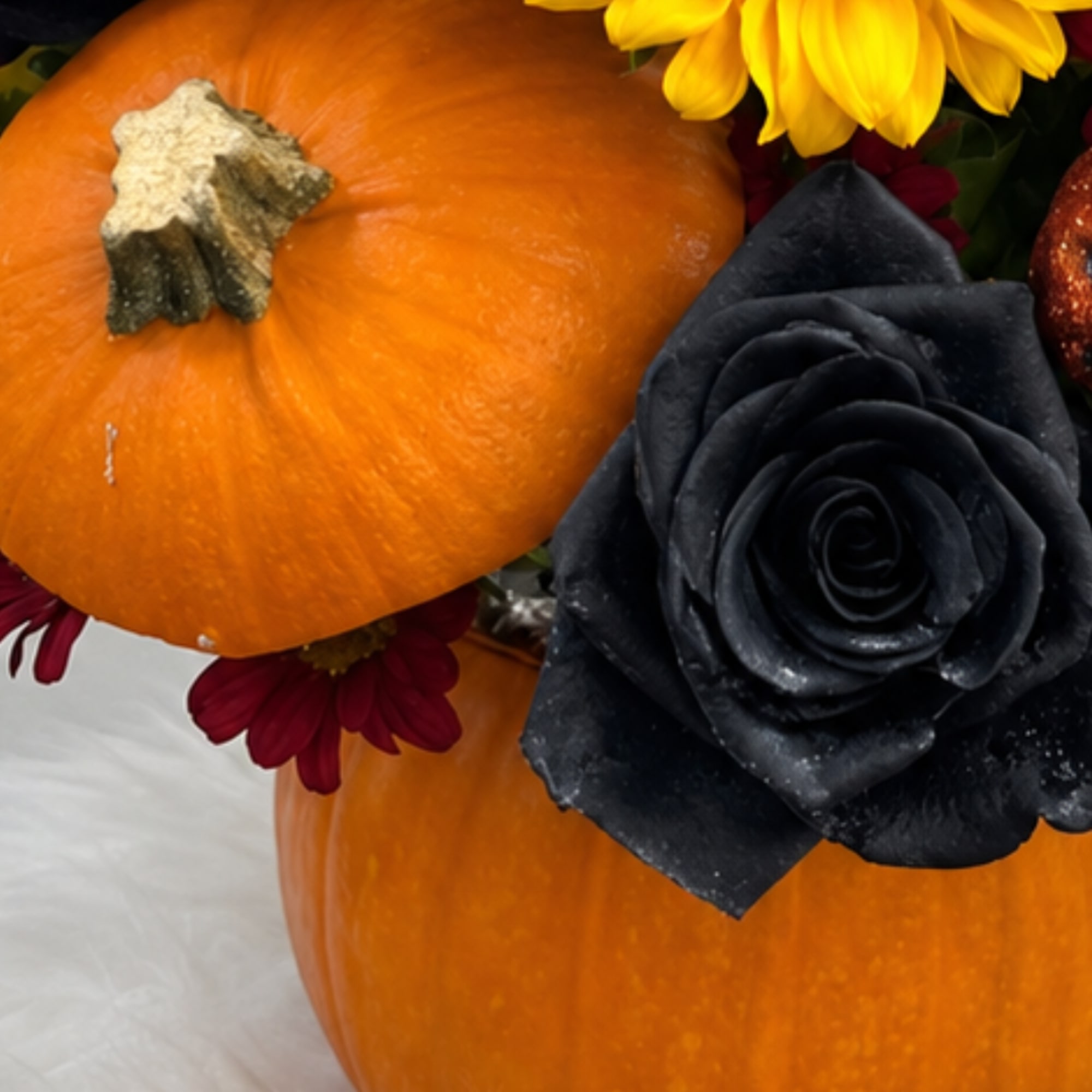 Pumpkins decorated with black and yellow flowers