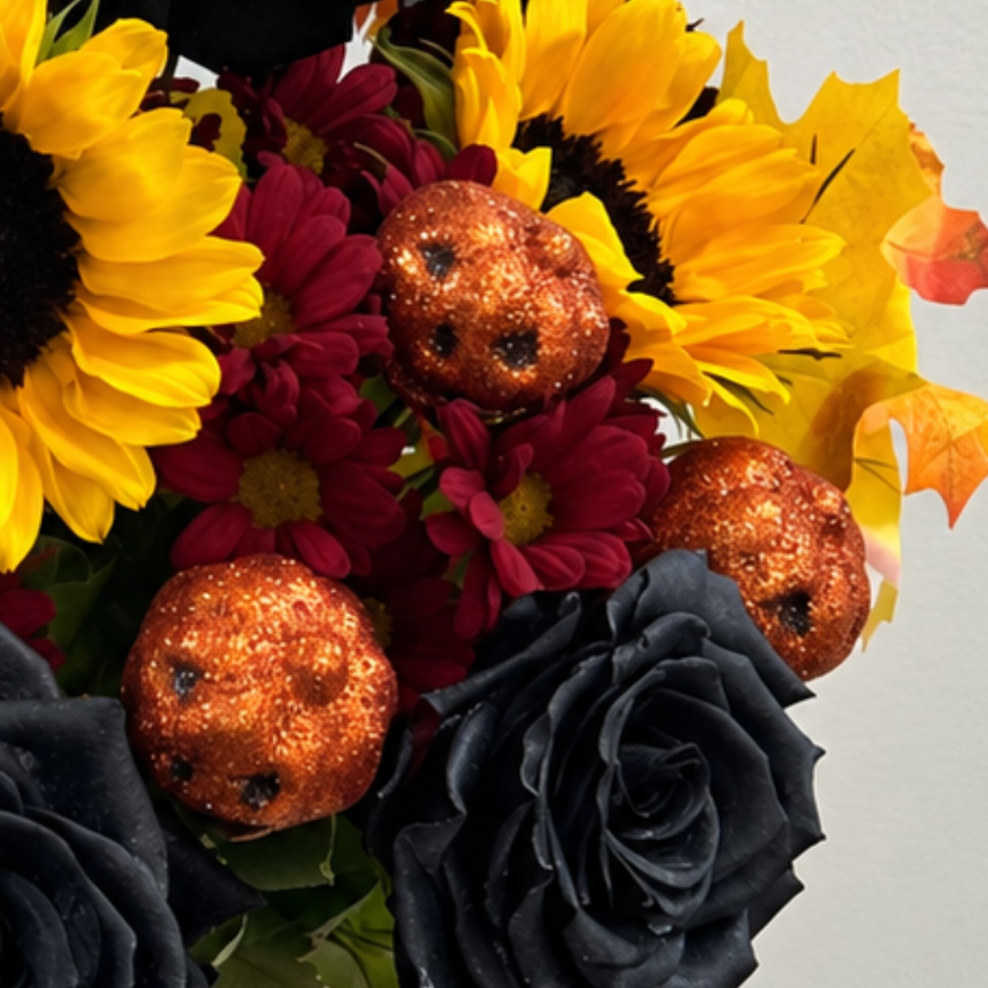 Bouquet with yellow sunflowers, burgundy daisies, and black roses with glittery orange accents