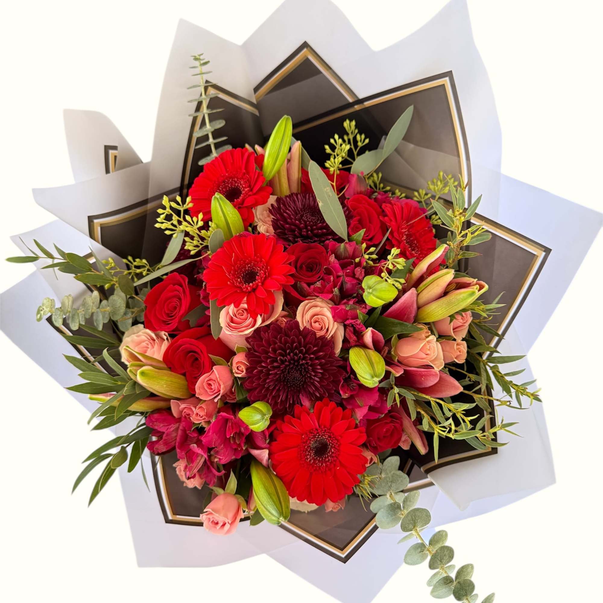 Bouquet of red gerberas, roses, and lilies with eucalyptus