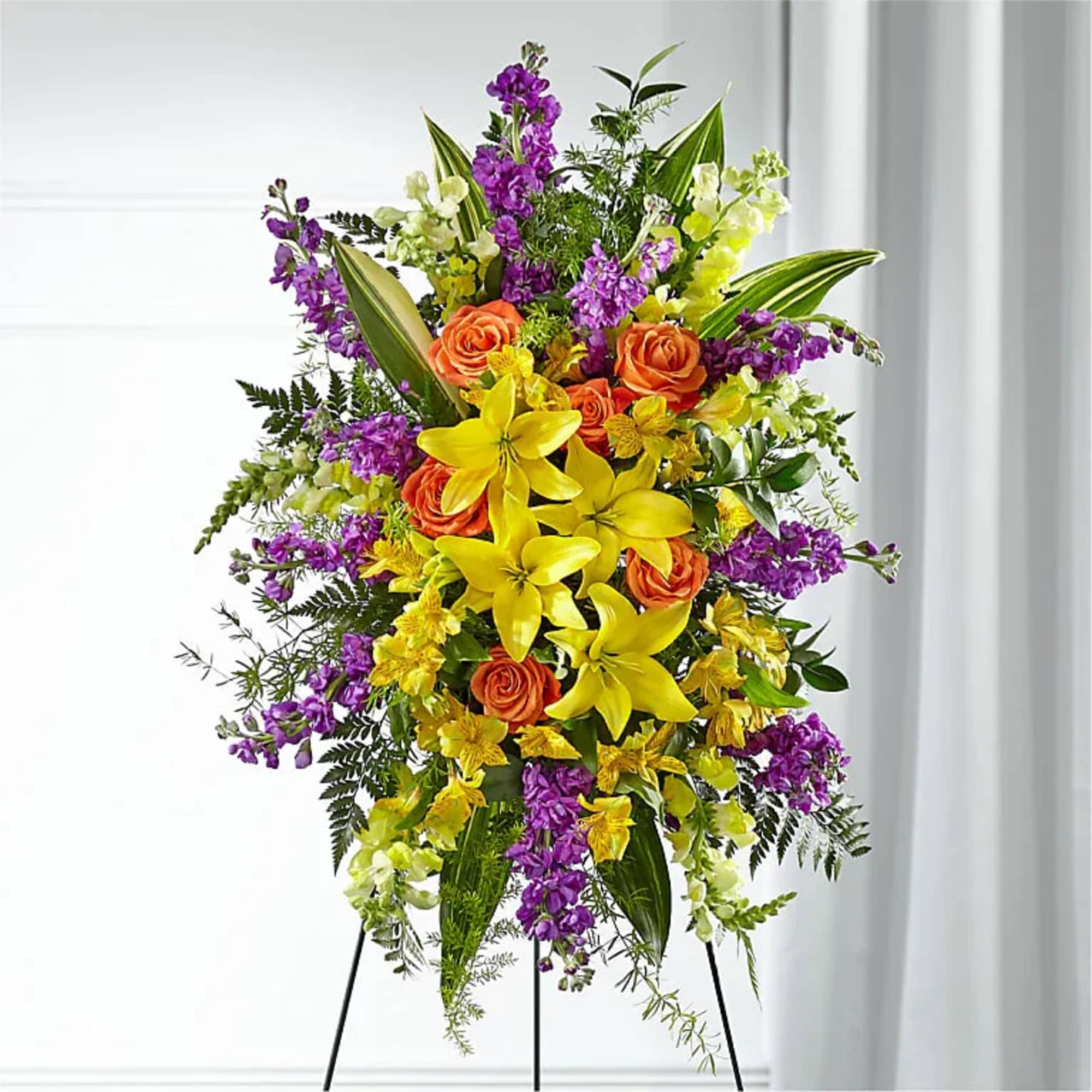 Bright yellow lilies and bold orange roses form a radiant central axis