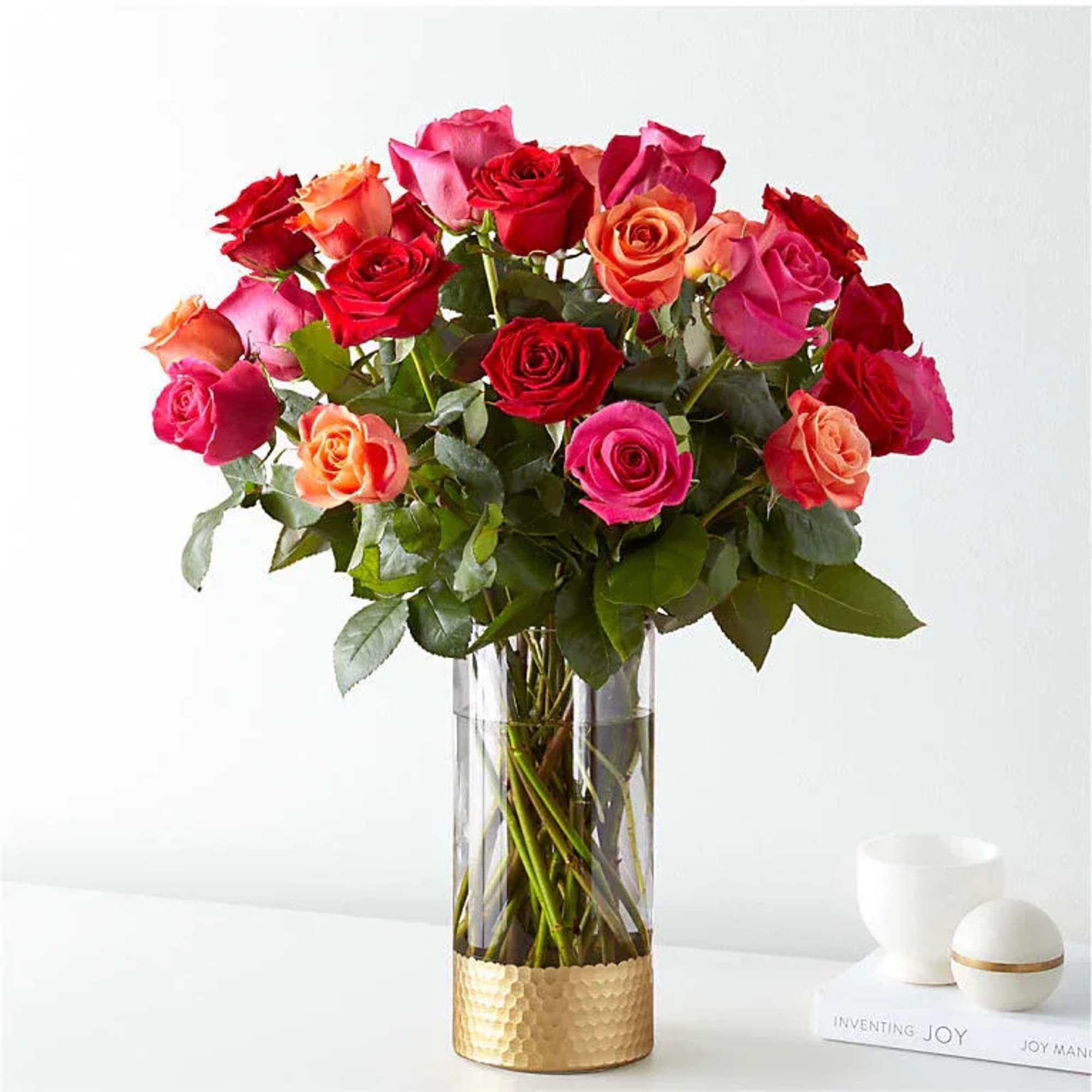 A lush cluster of roses in vivid pinks, reds, peaches and pops