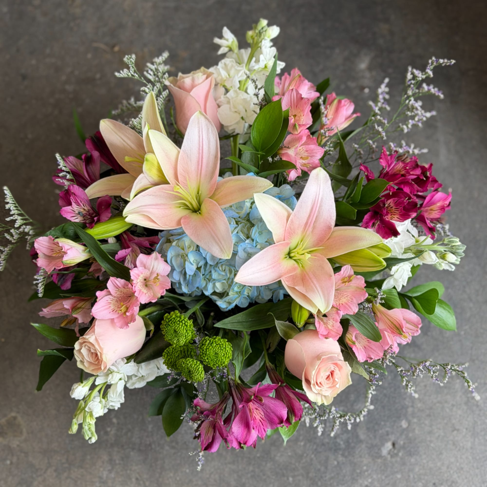 Mixed bouquet with pink lilies, roses, and blue hydrangea