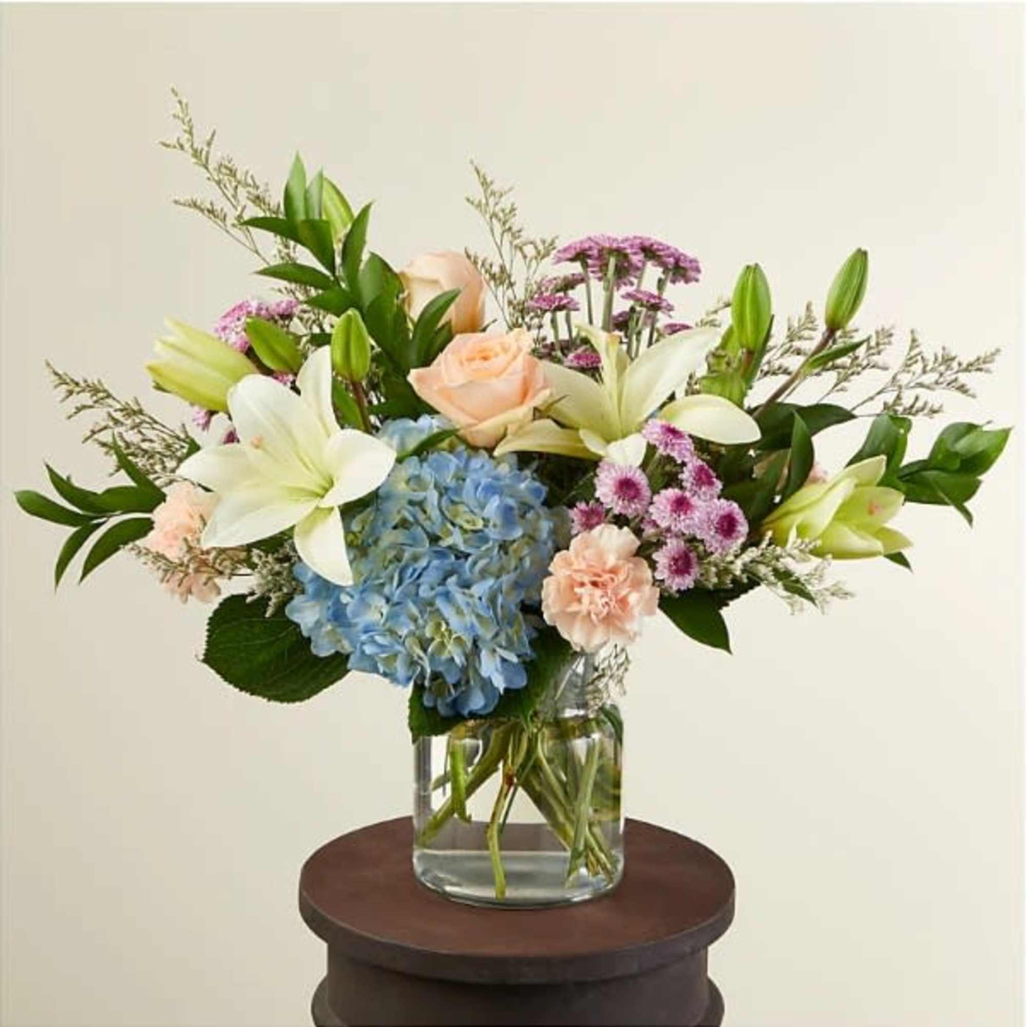 A beautiful arrangement of calming colors pairing perfectly with peach-colored flowers. Available