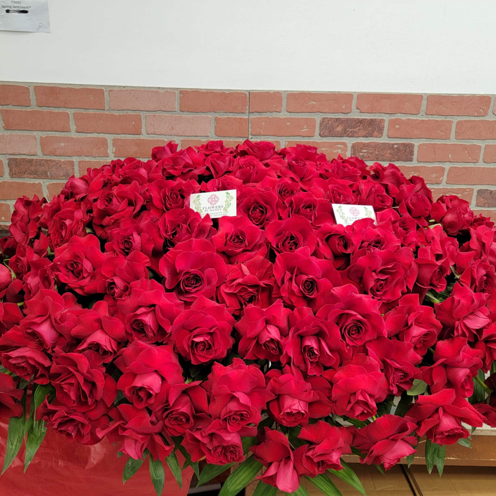 Red roses and white flowers in this full casket symbolize love and