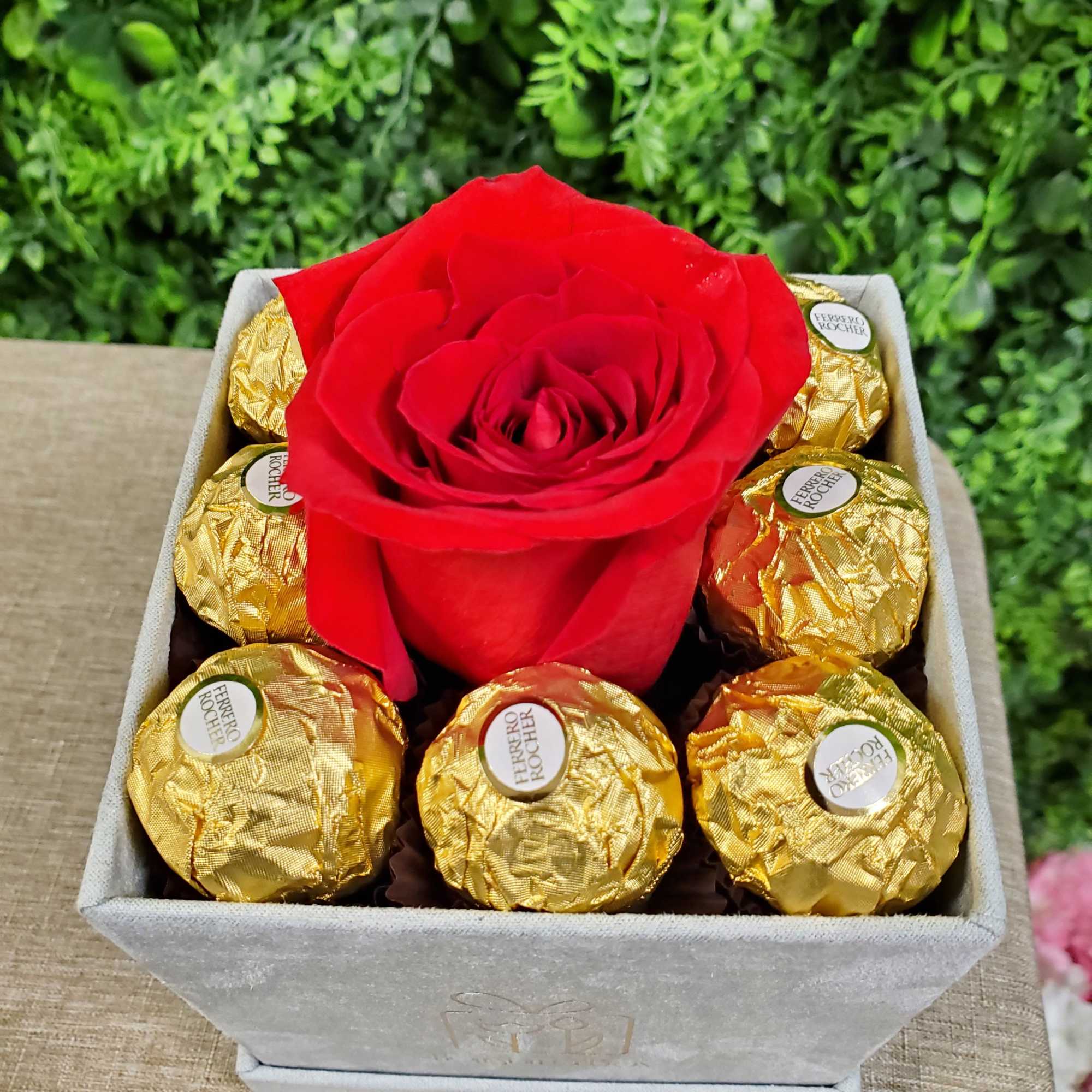 Red rose surrounded by chocolates 
