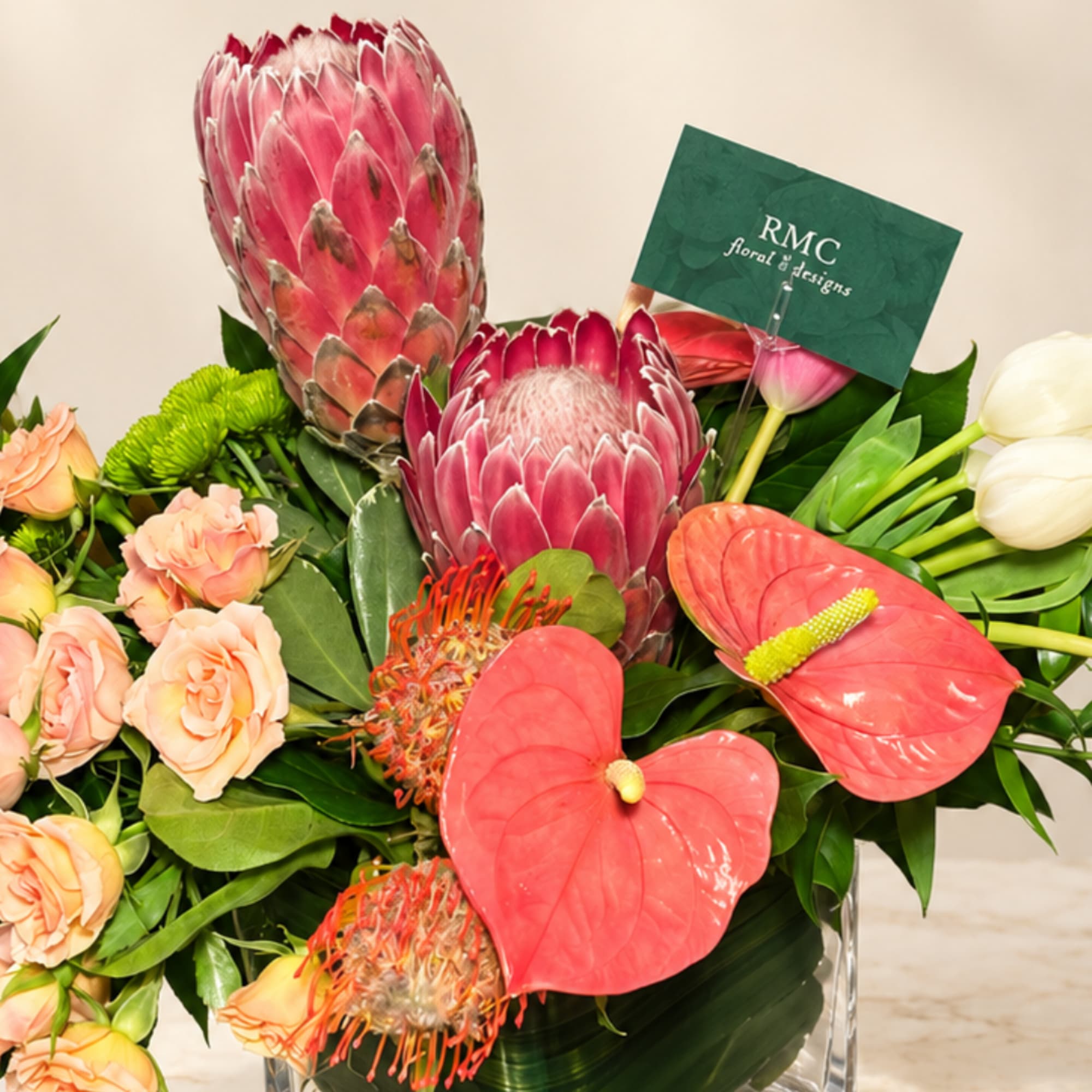 Tropical bouquet with pink protea, coral anthuriums, and peach roses