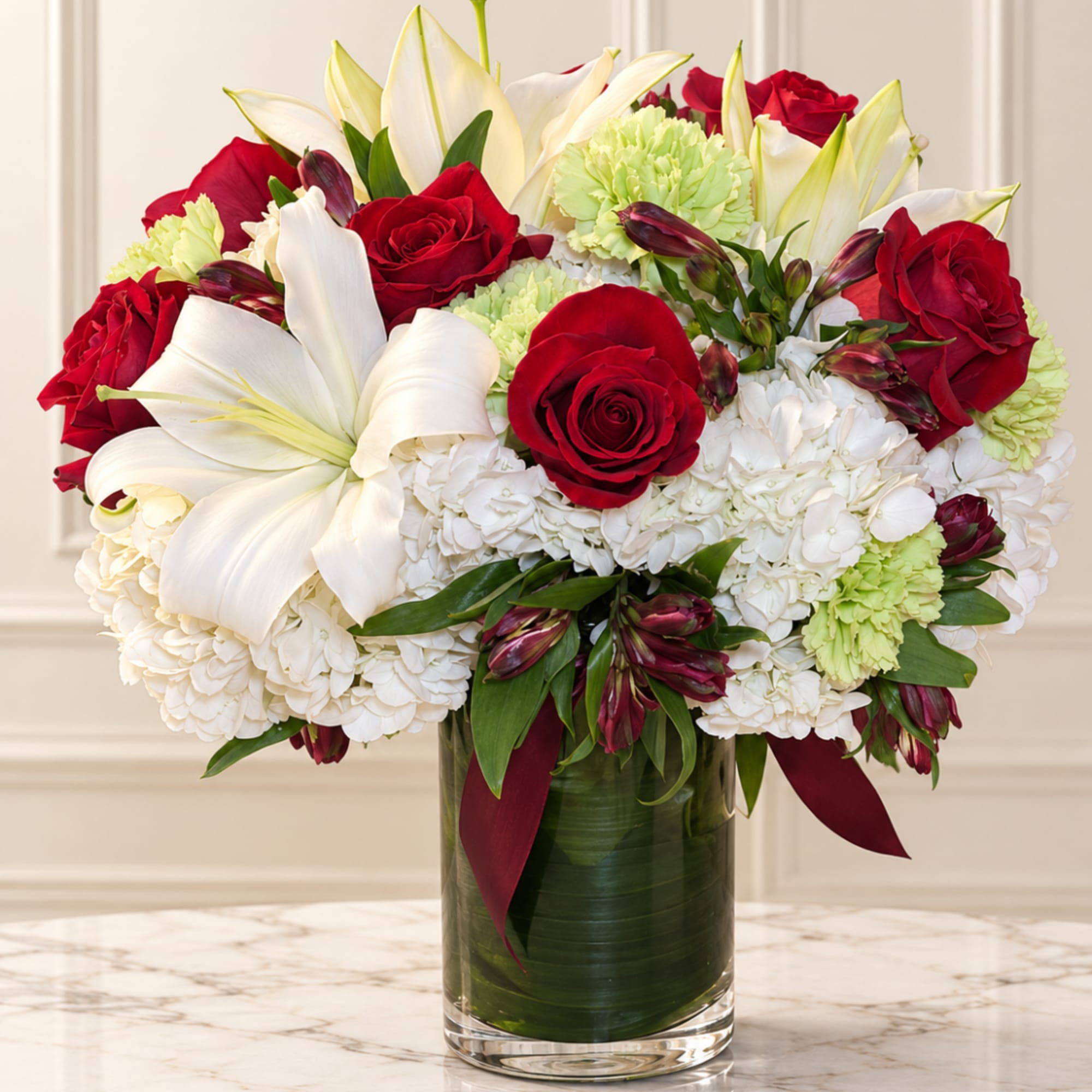 Red roses and white lilies in a glass vase with white hydrangeas