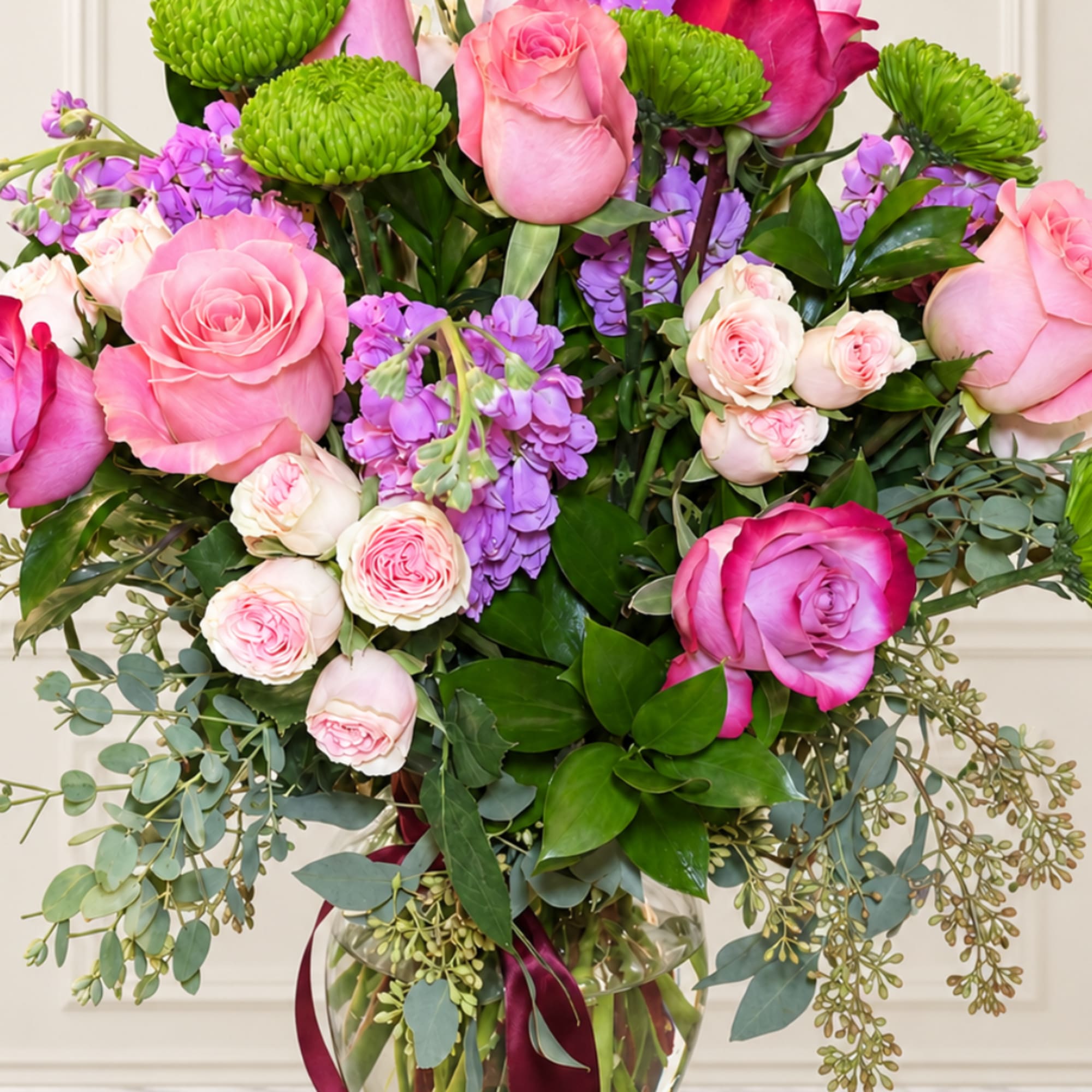 Pink and purple rose bouquet in a glass vase