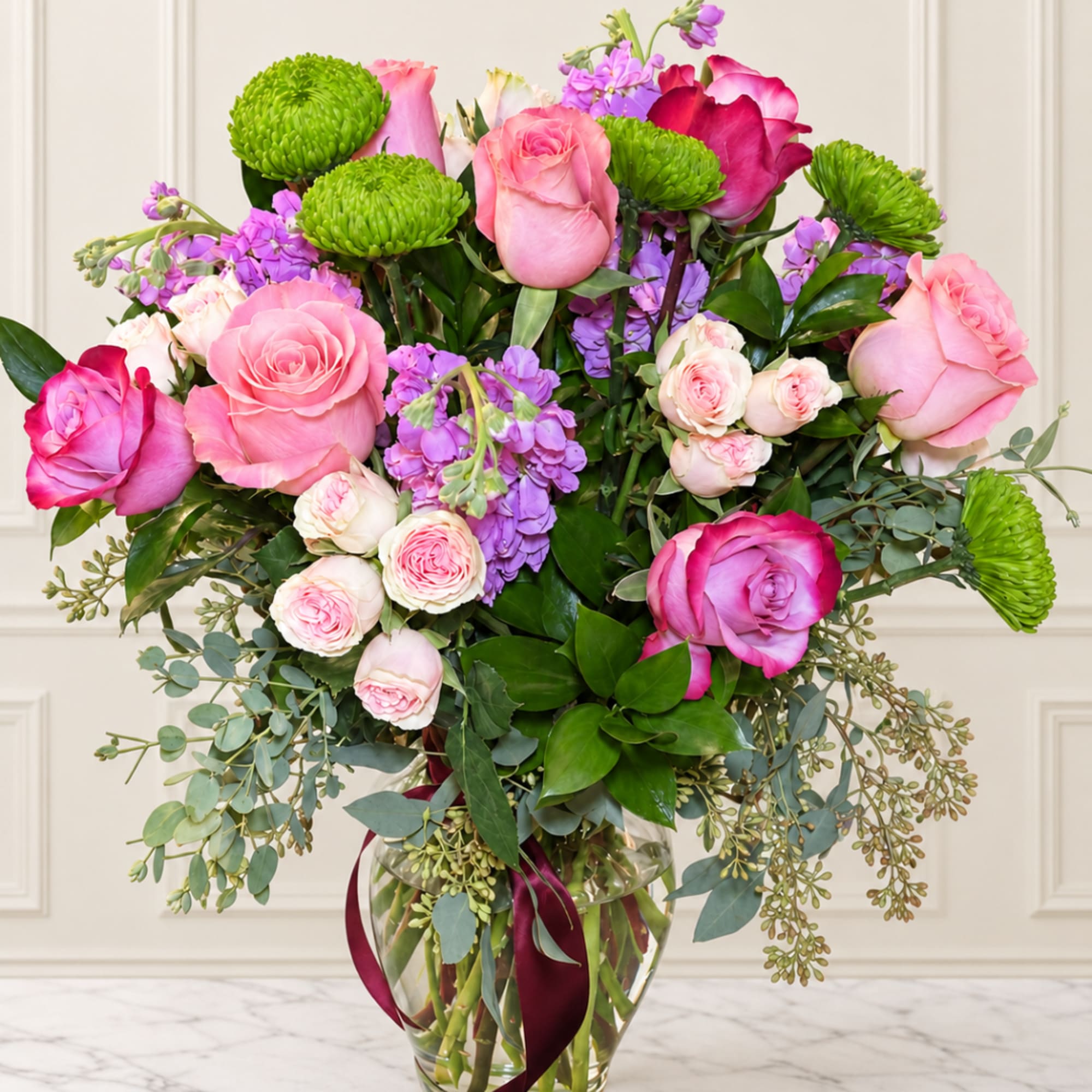Pink and purple rose bouquet in a clear glass vase