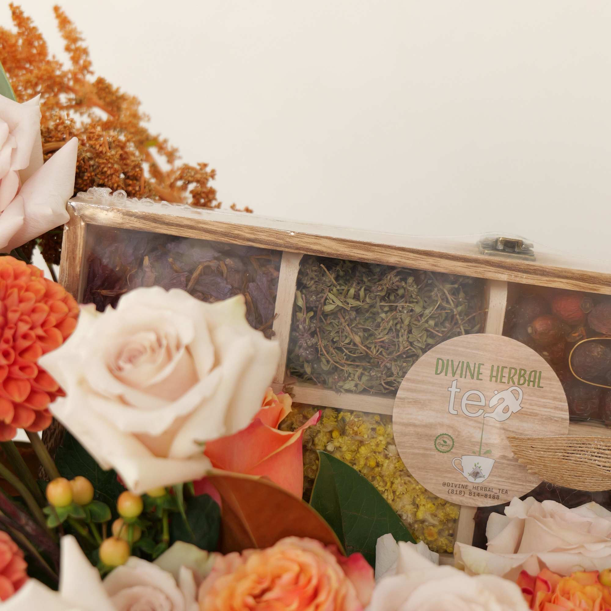 Bouquet of pale roses and orange blooms beside a boxed herbal tea set