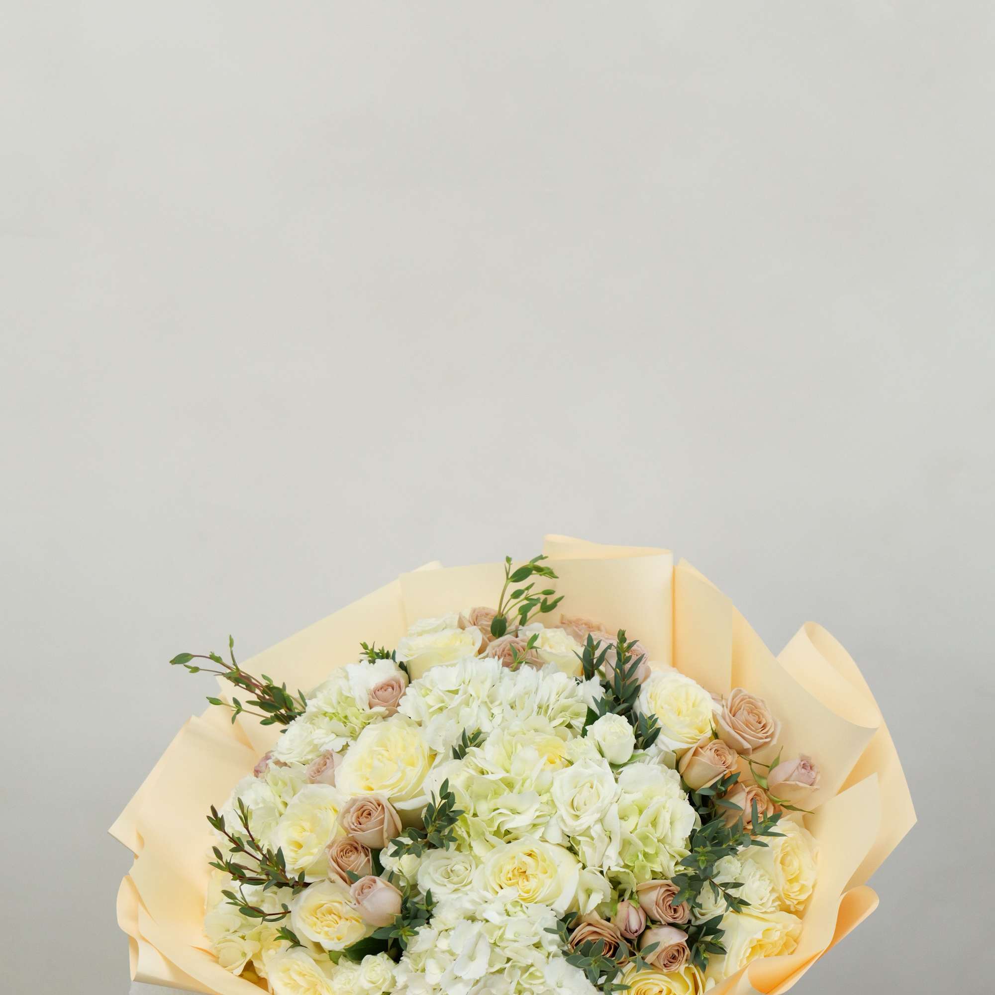 An elegant bouquet of creamy roses and premium florals, carefully designed to