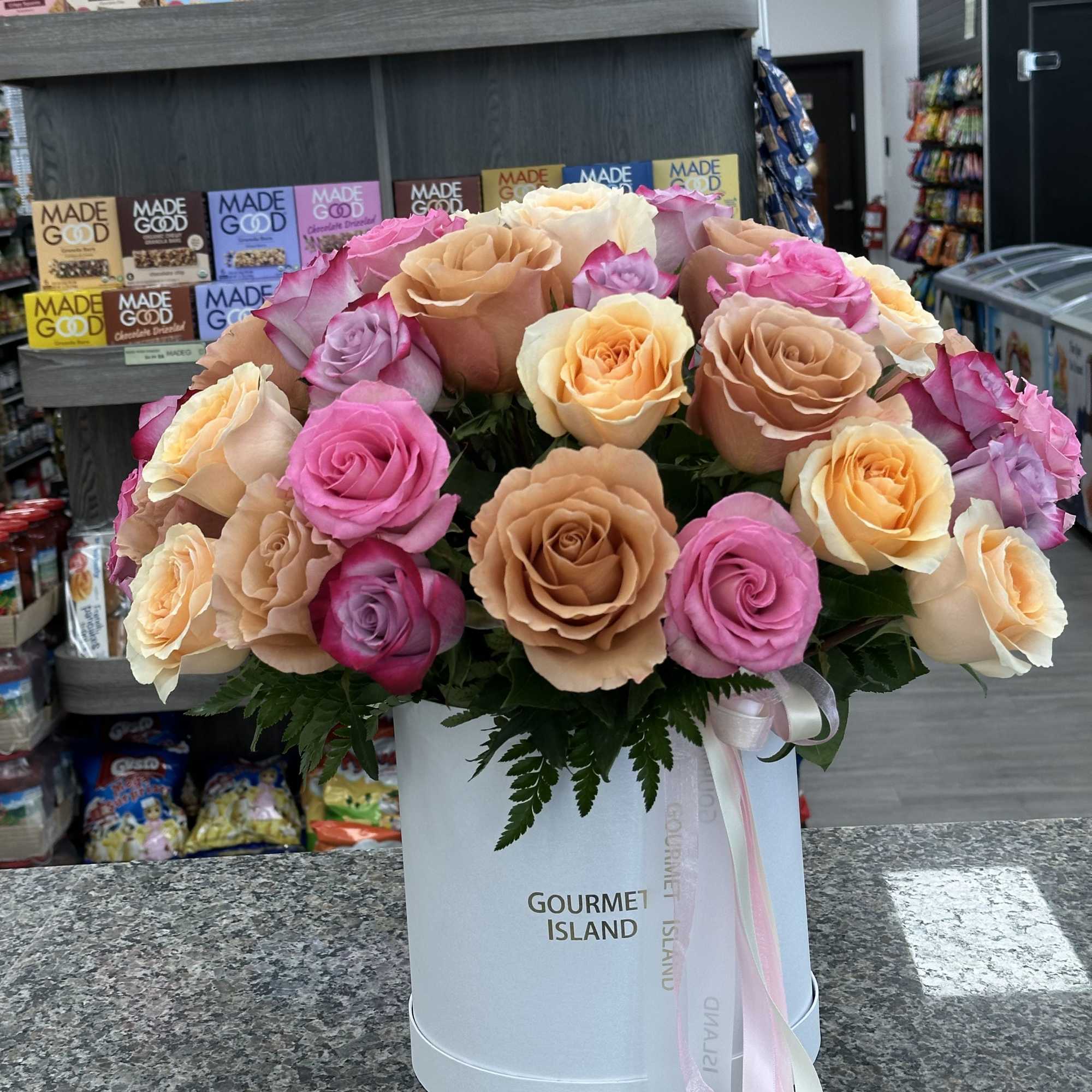 Bouquet of multicolored roses in a white hat box with ribbon