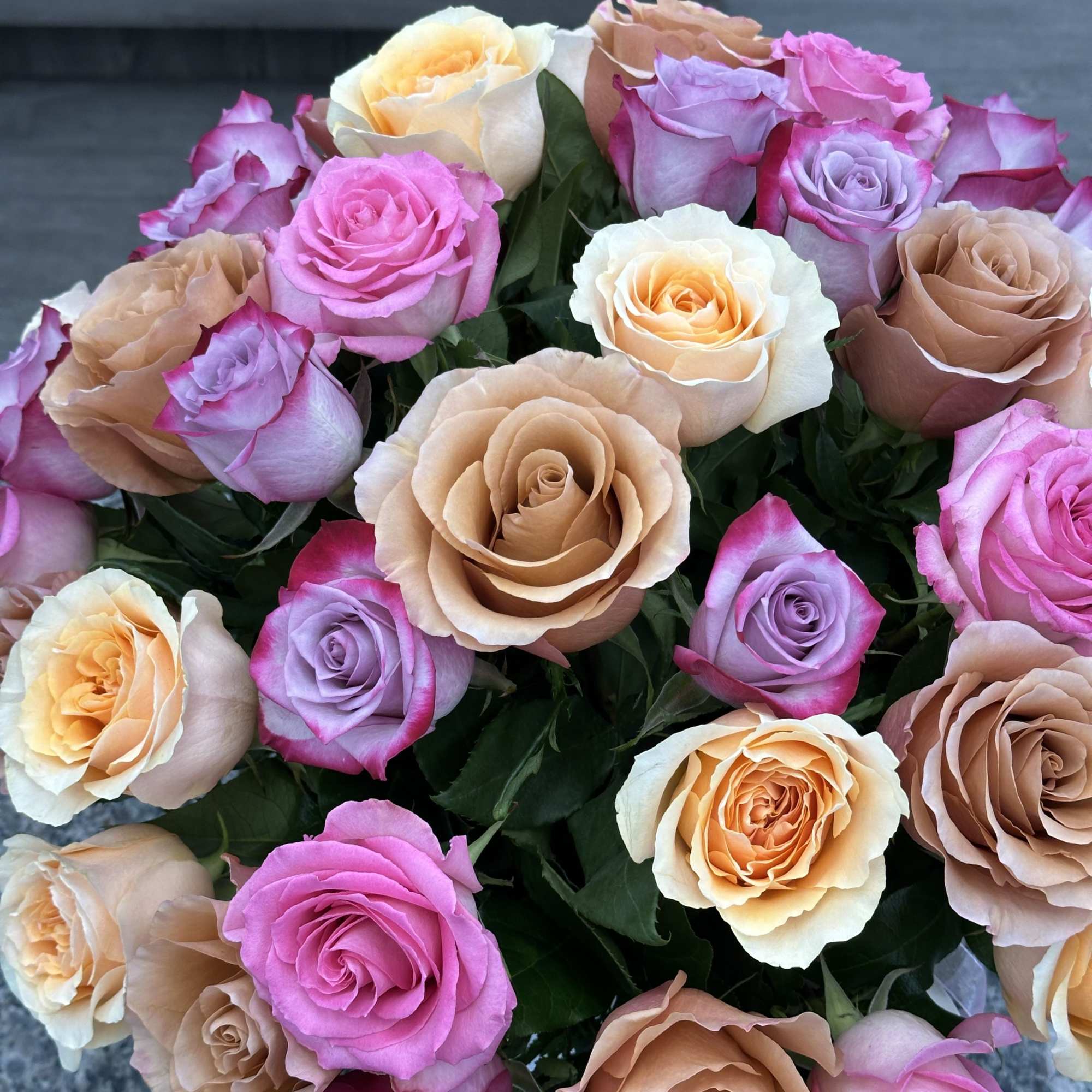 Bouquet of multicolored roses in pink, peach, lavender, and cream