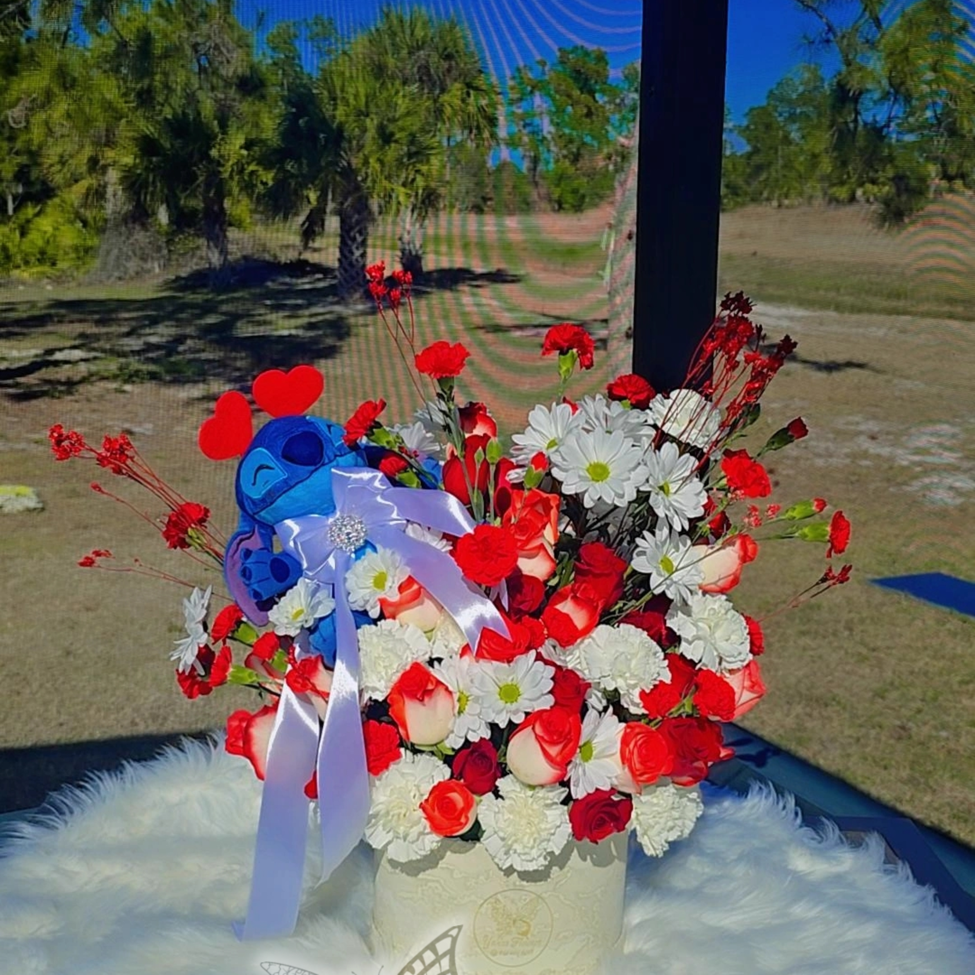 Our round box floral centerpiece with a Stitch plush is the perfect