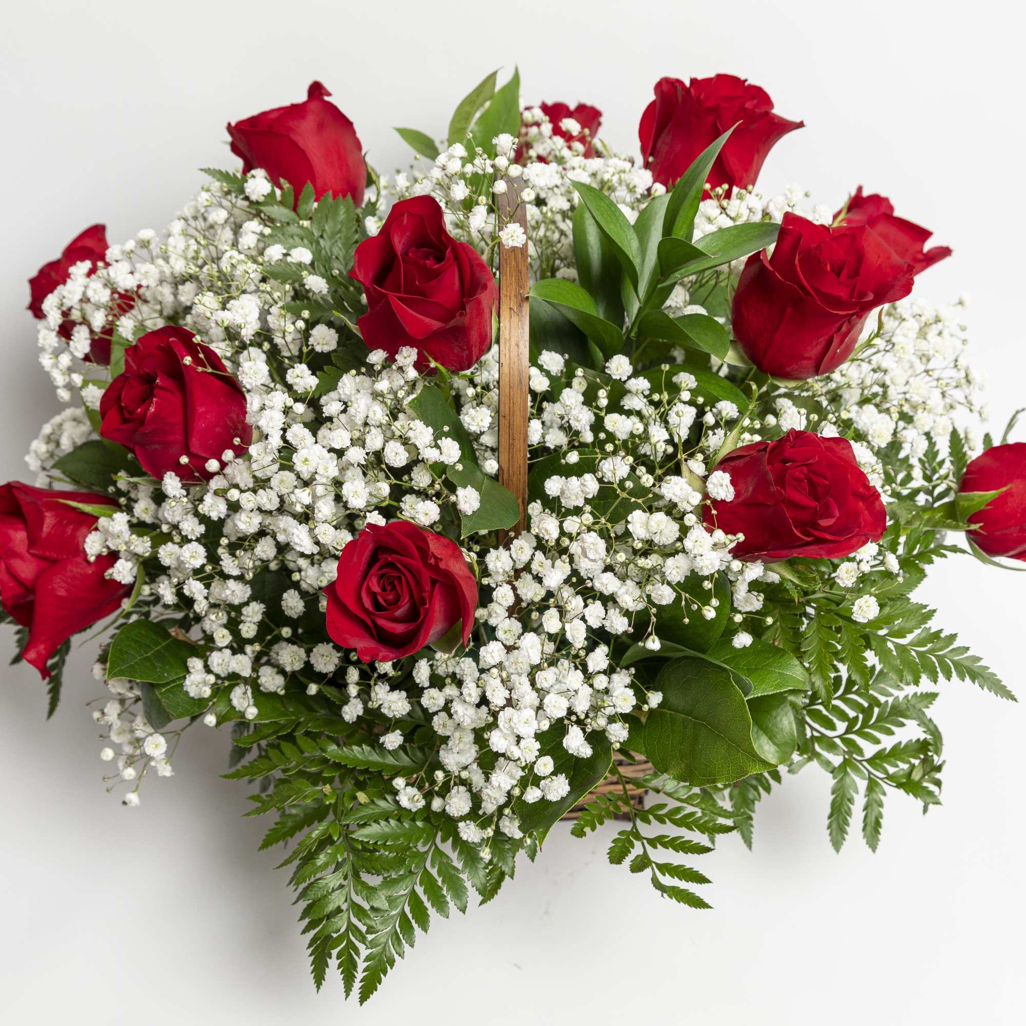 Red roses arranged with white baby's breath in a basket
