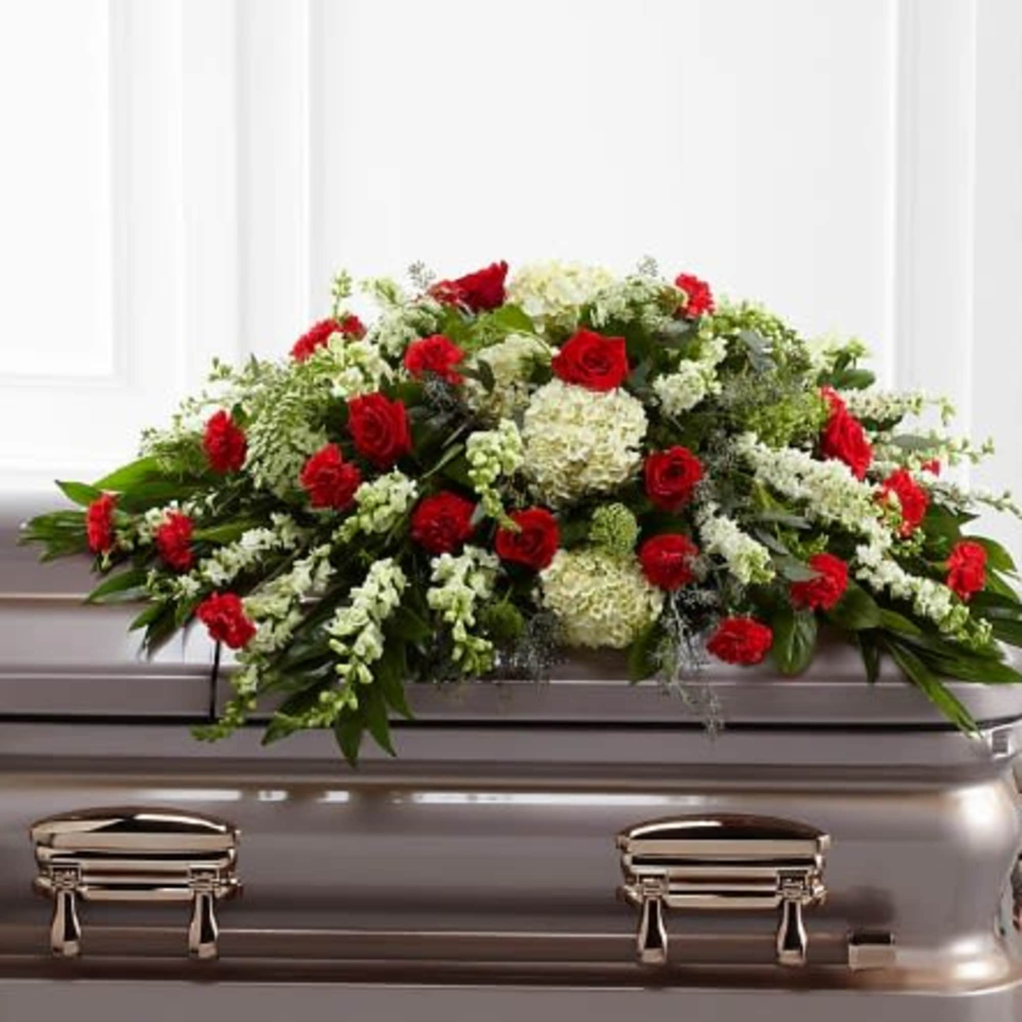 Red and white floral spray on a casket