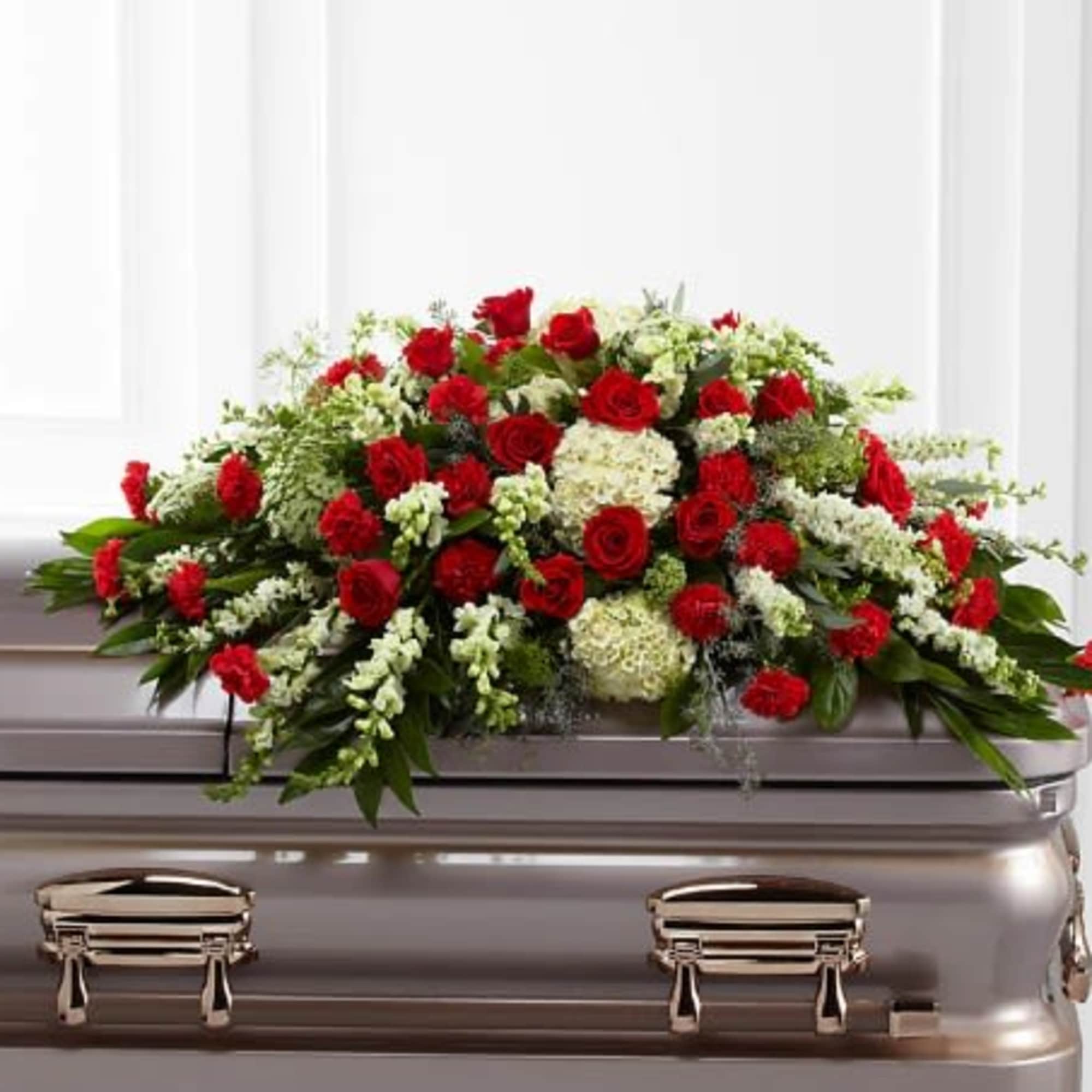 Red and white floral spray on a silver casket