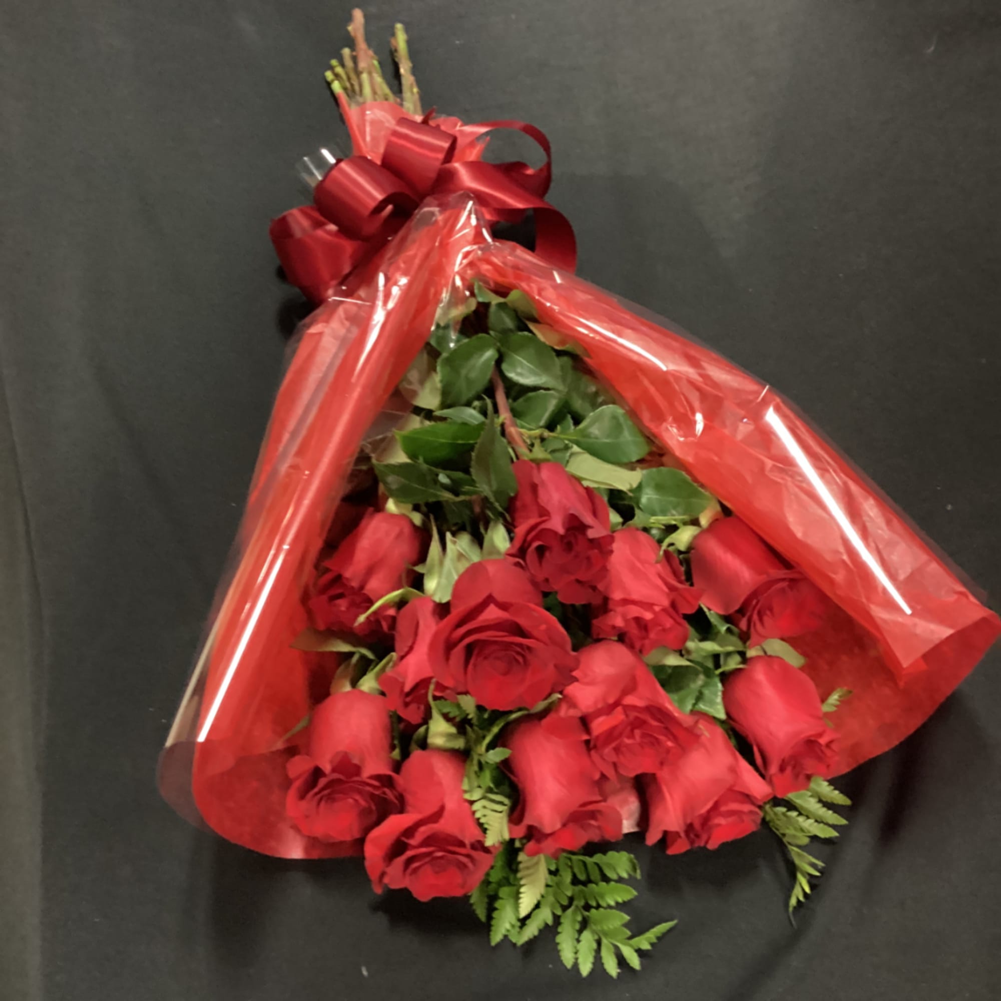 Bouquet of red roses wrapped in red cellophane with a ribbon