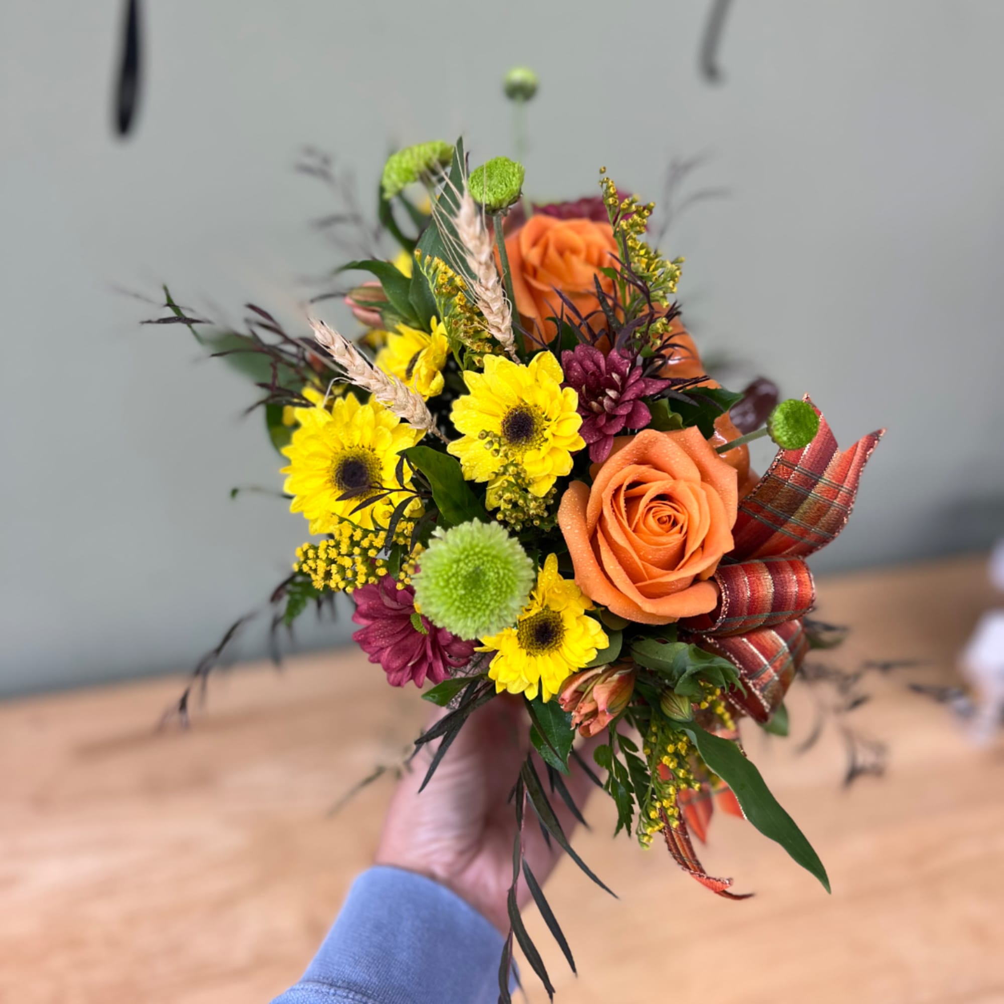 Handheld bouquet with orange roses and yellow daisies